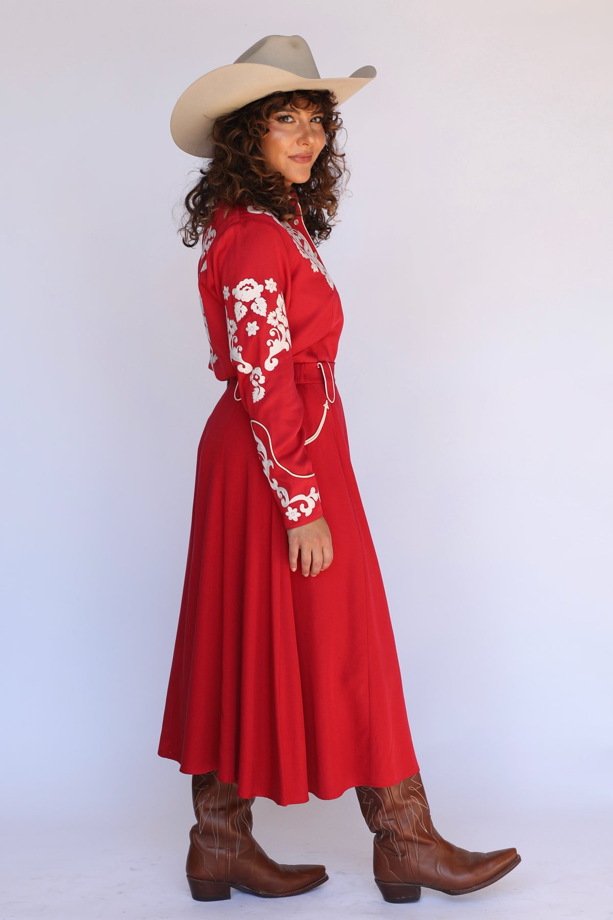 Profile of a woman in a cowboy hat wearing the H Bar C Santa Fe red dance skirt.