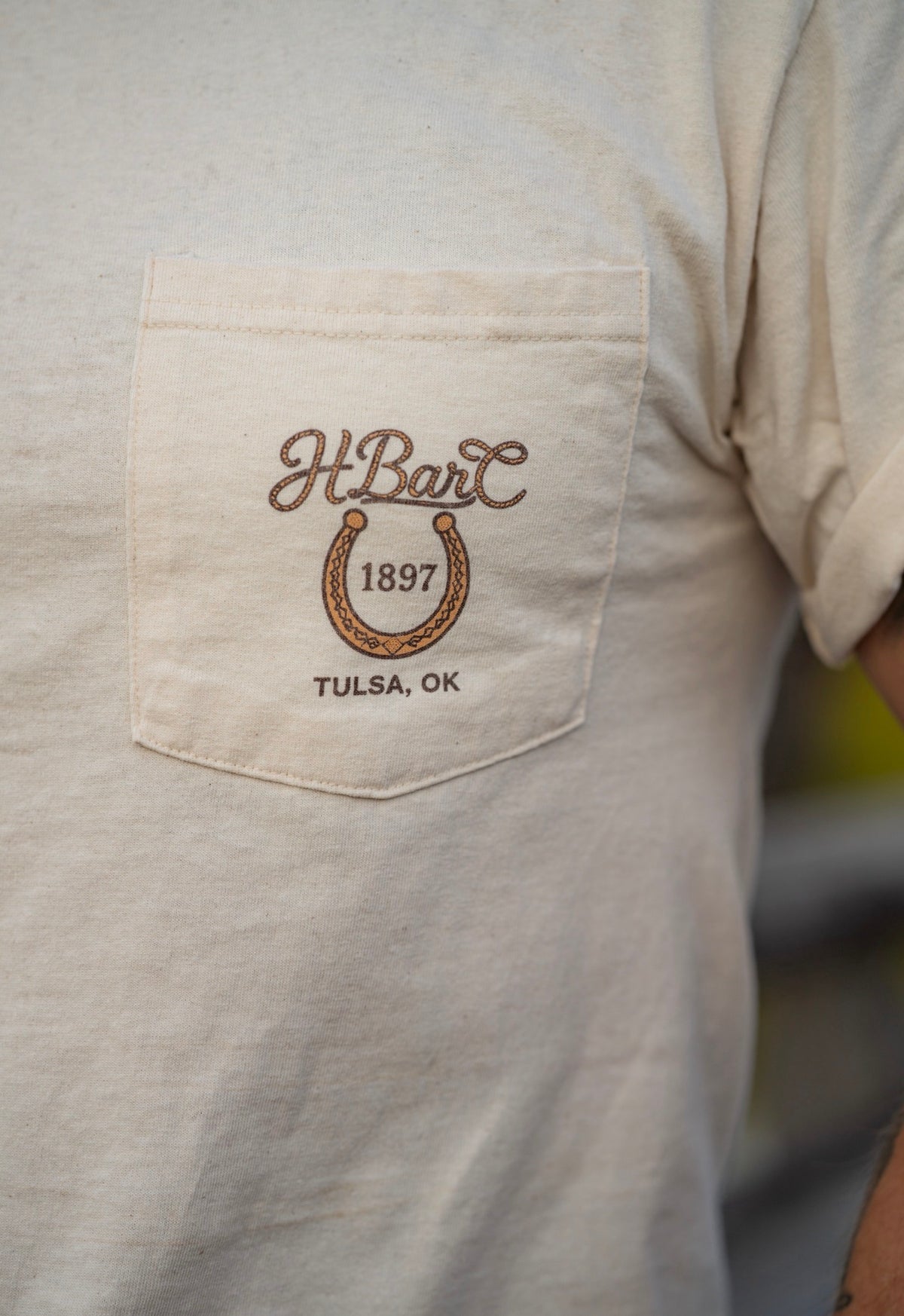 Pocket logo detail of the cream H Bar C Tulsa Rope T-shirt from the Tulsa store on Route 66.