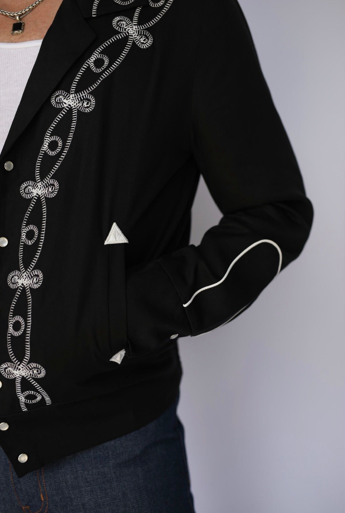 Detail of the embroidery along the front and sleeve of the H Bar C Bolero El Patrón black jacket.