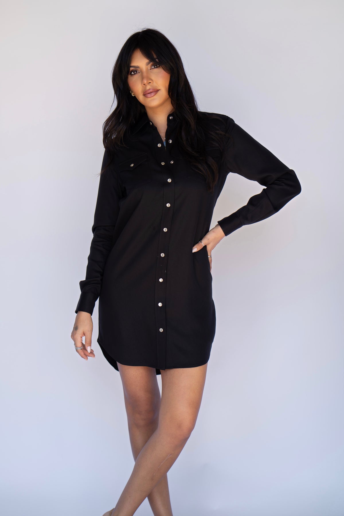 Front view of the H Bar C Savannah black dress worn with hand on hip, showing the relaxed taper, snap front, and western pockets.