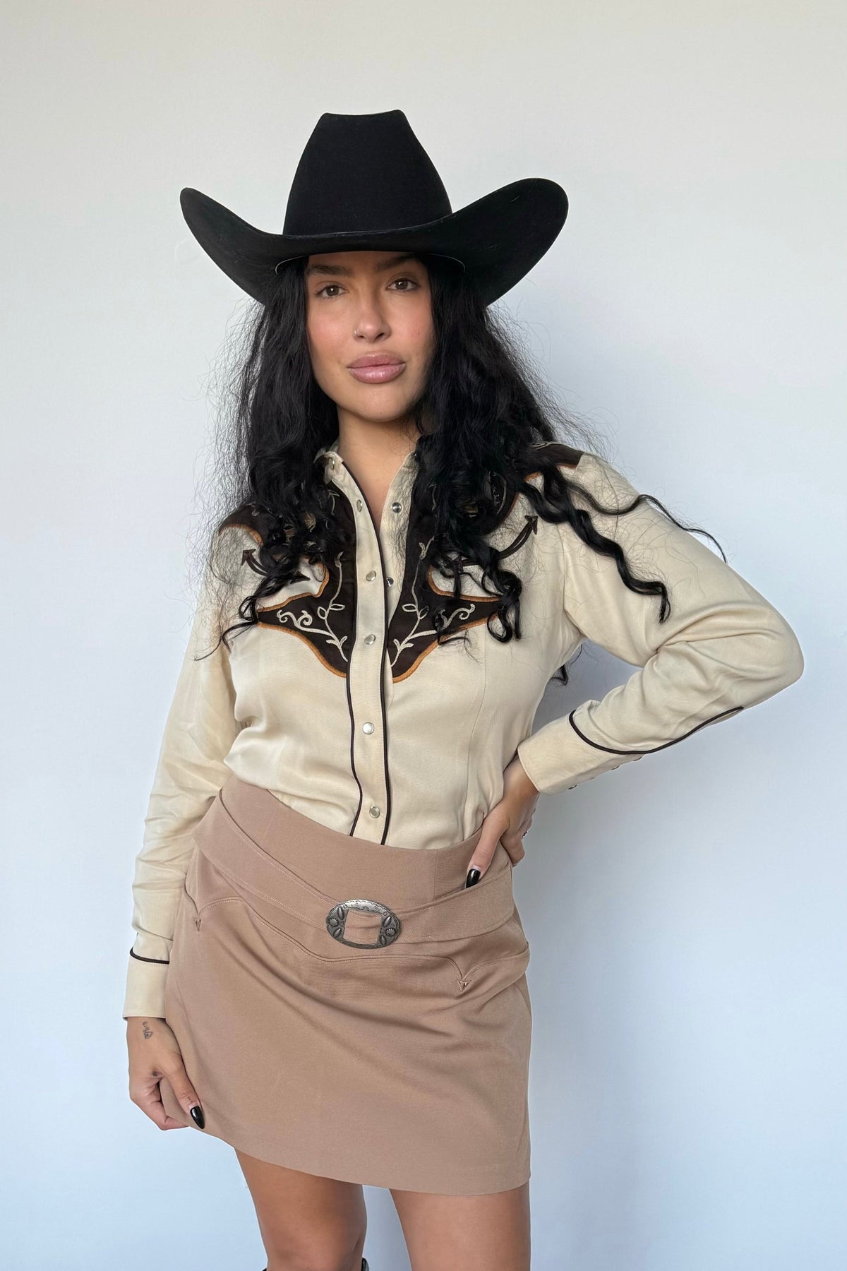 Full length view of the H Bar C Santa Barbara women's shirt with a tan skirt and black cowboy hat.