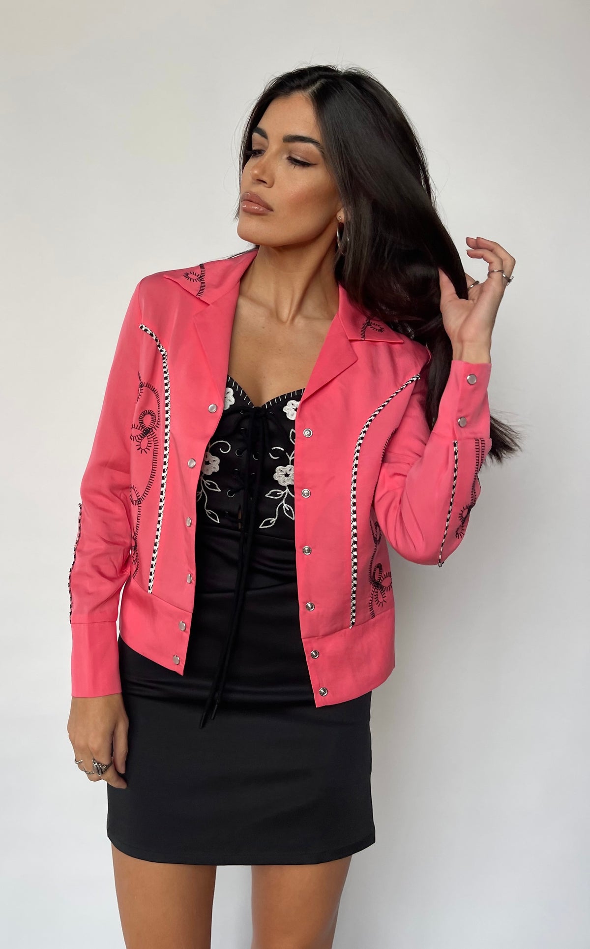 Front view of the H Bar C Bolero women's pink jacket with a black mini skirt.