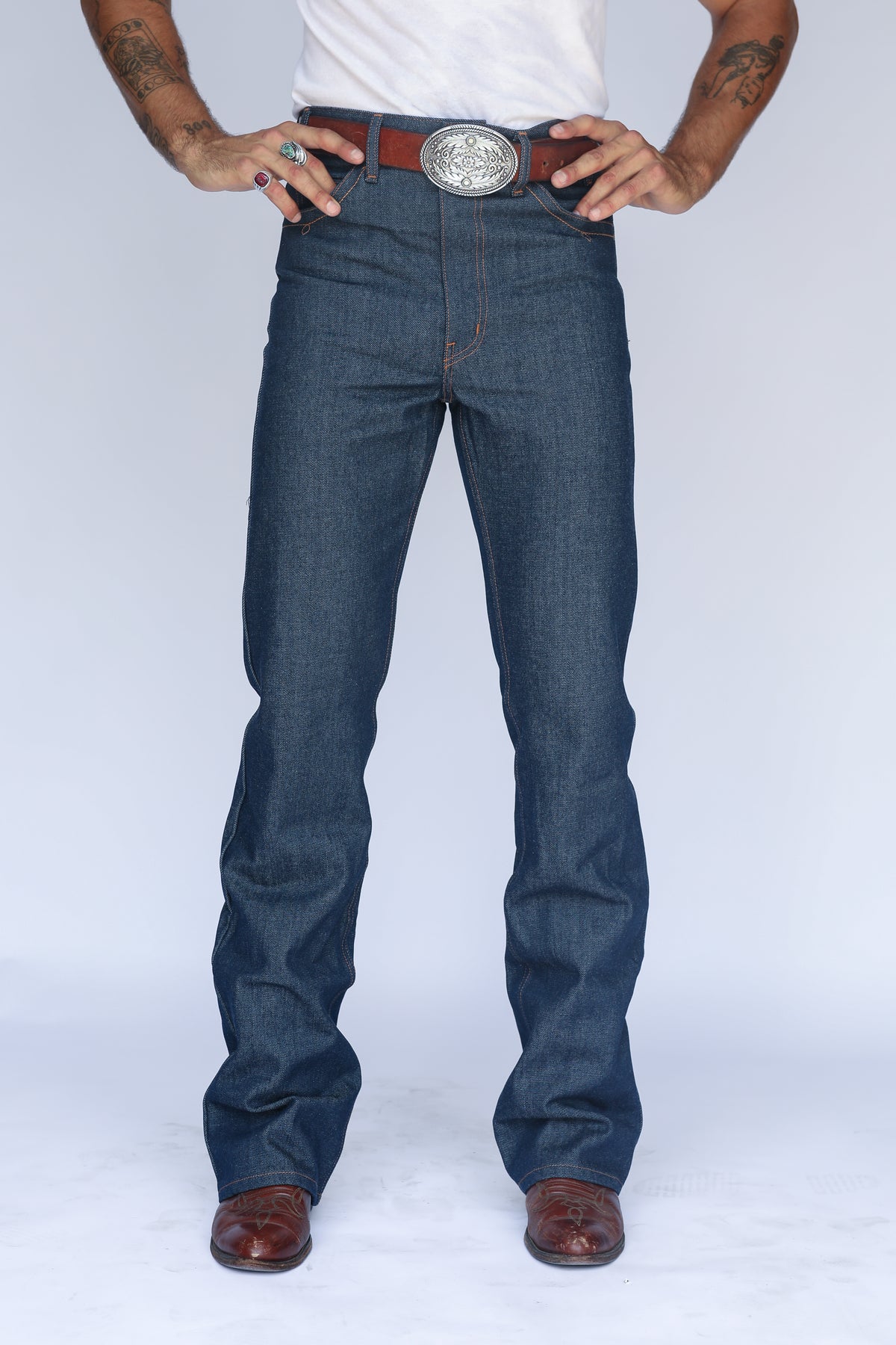 Front view from the waist down of the H Bar C Boot Cut Flare indigo jeans with boots.