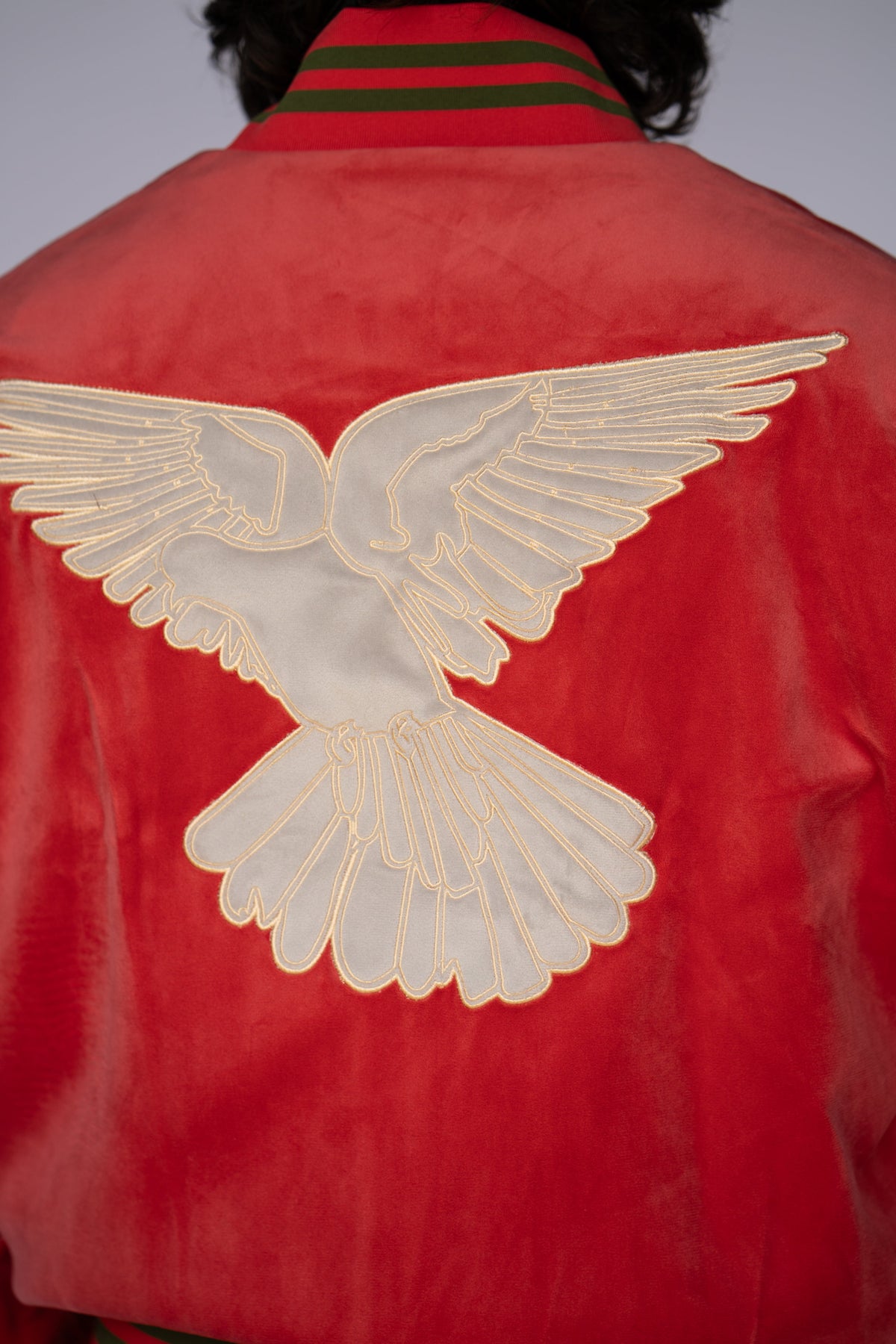 Close-up of the large white dove embroidered on the back of the HBarC x Gibson Dove red tour jacket.