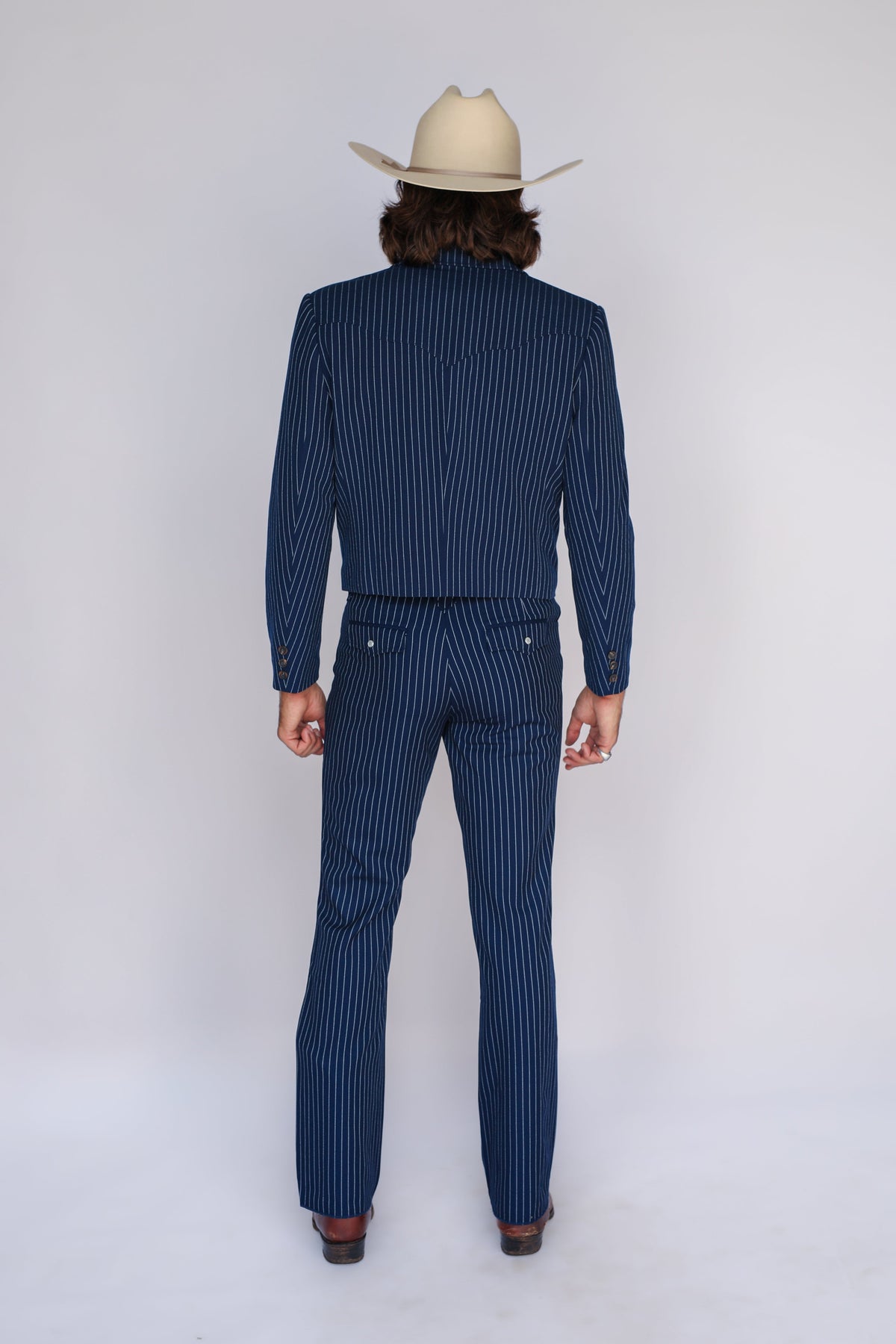 Back view of the H Bar C Bakersfield navy pin stripe western suit with a cream cowboy hat.