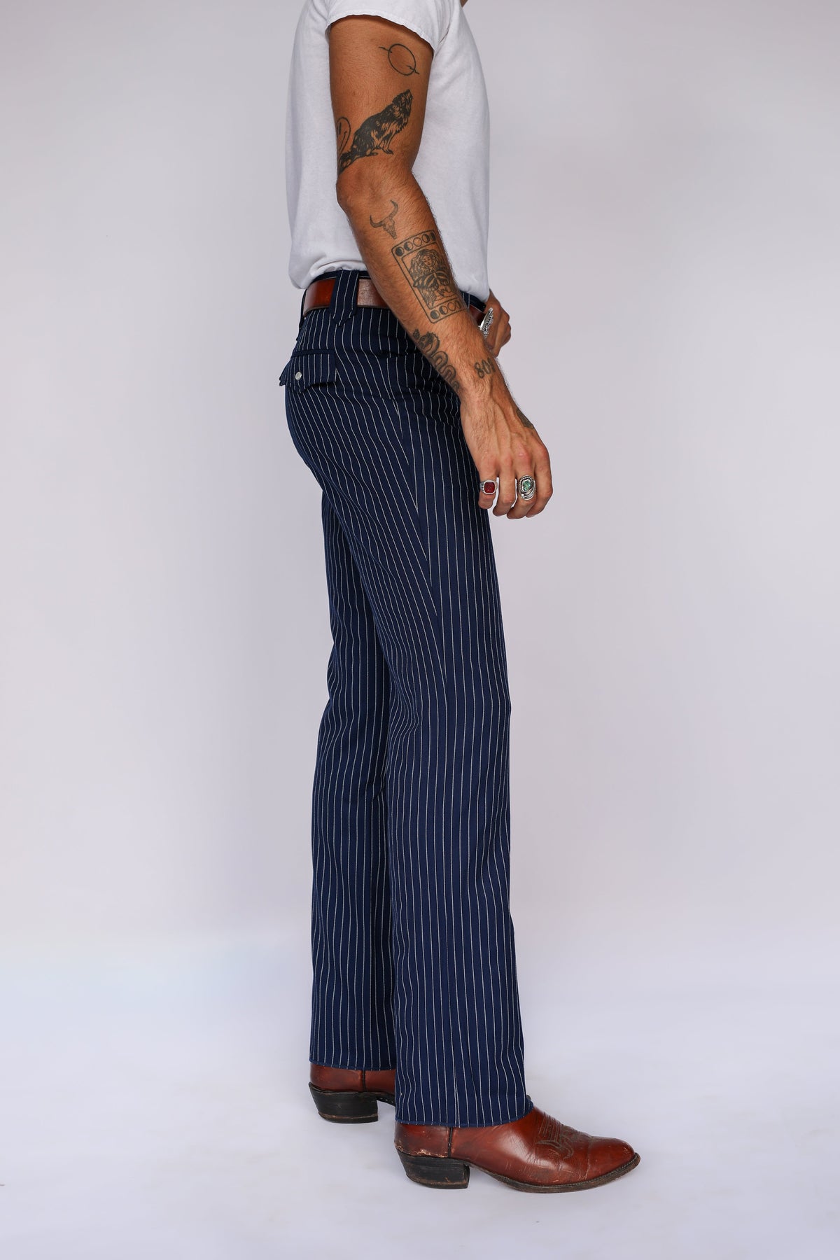 Side profile of the H Bar C Bakersfield navy pinstripe pants with a straight leg over brown cowboy boots.