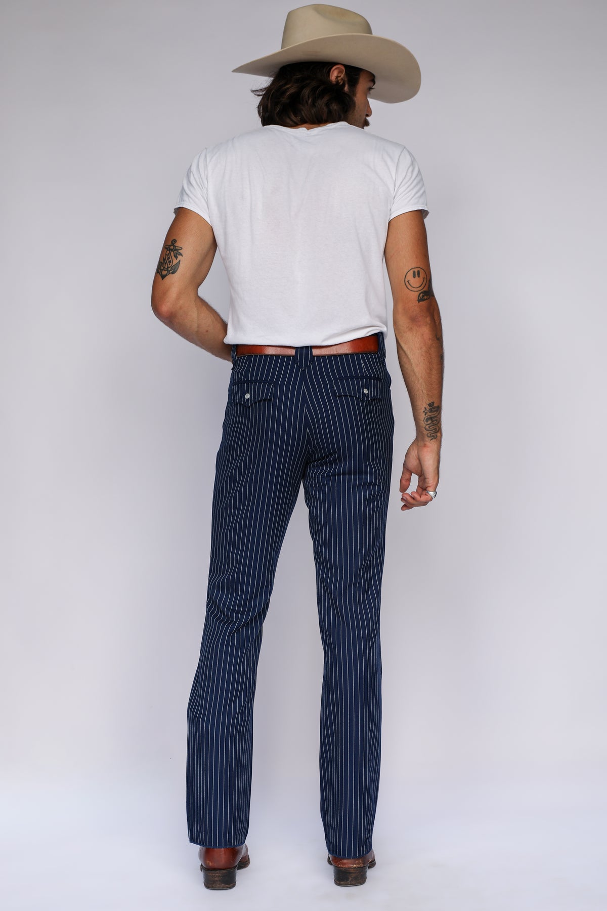 Full back view of the H Bar C Bakersfield navy pinstripe pants worn with a white tee and cowboy hat.