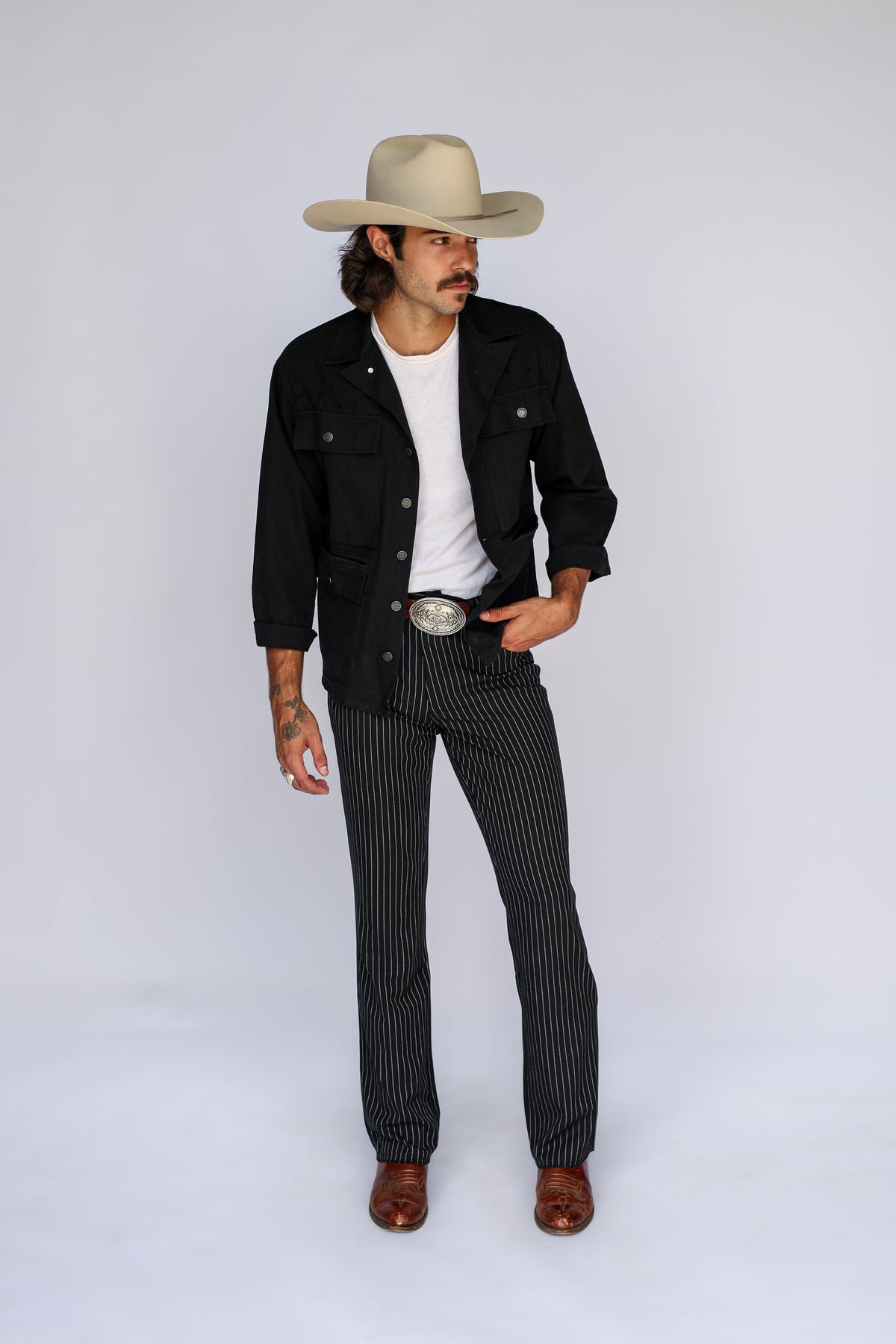 Man wearing the H Bar C Normandy vintage military inspired black chore coat and cowboy hat.