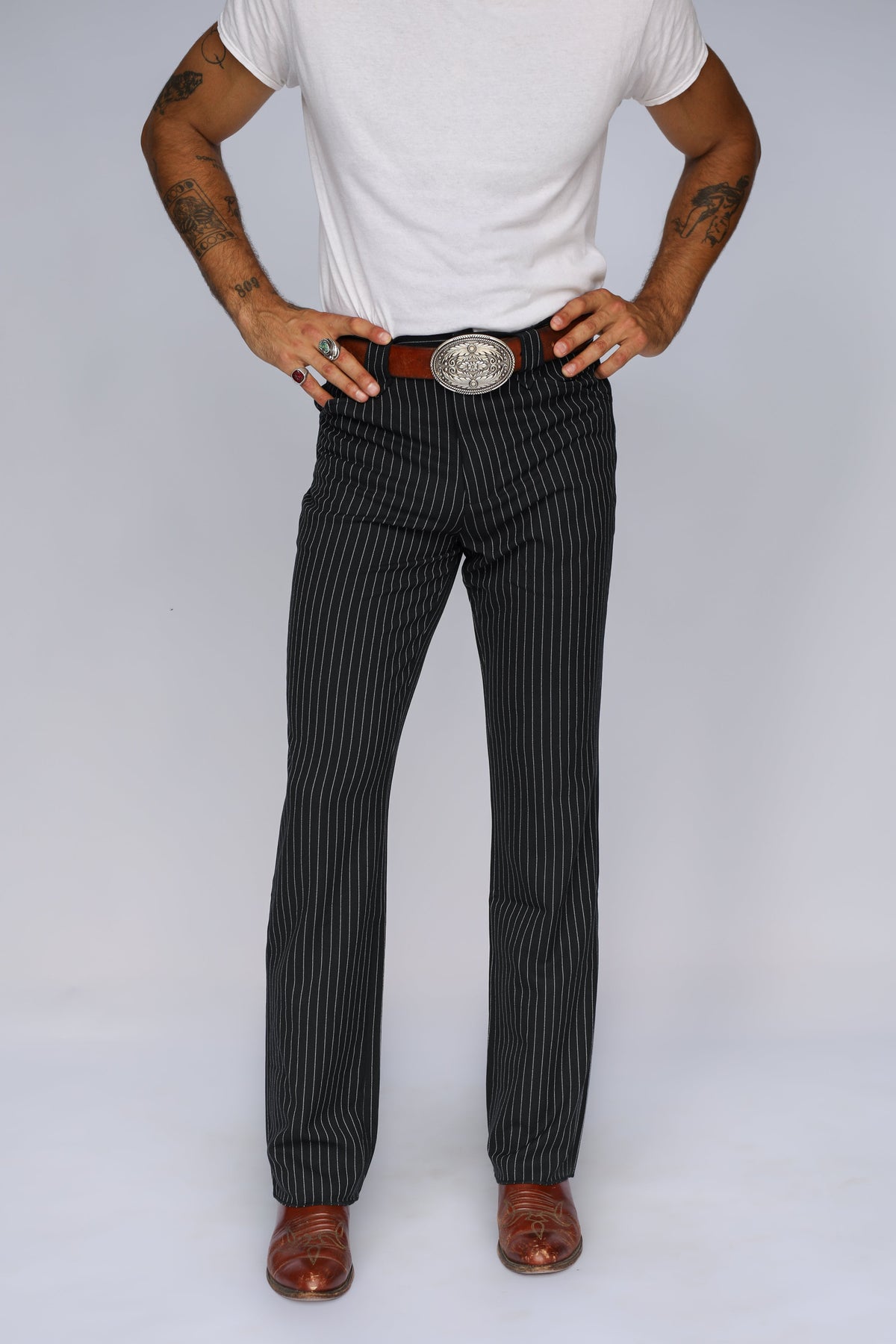 Front view of the H Bar C Bakersfield black pin stripe dress pants with a brown belt and silver buckle.
