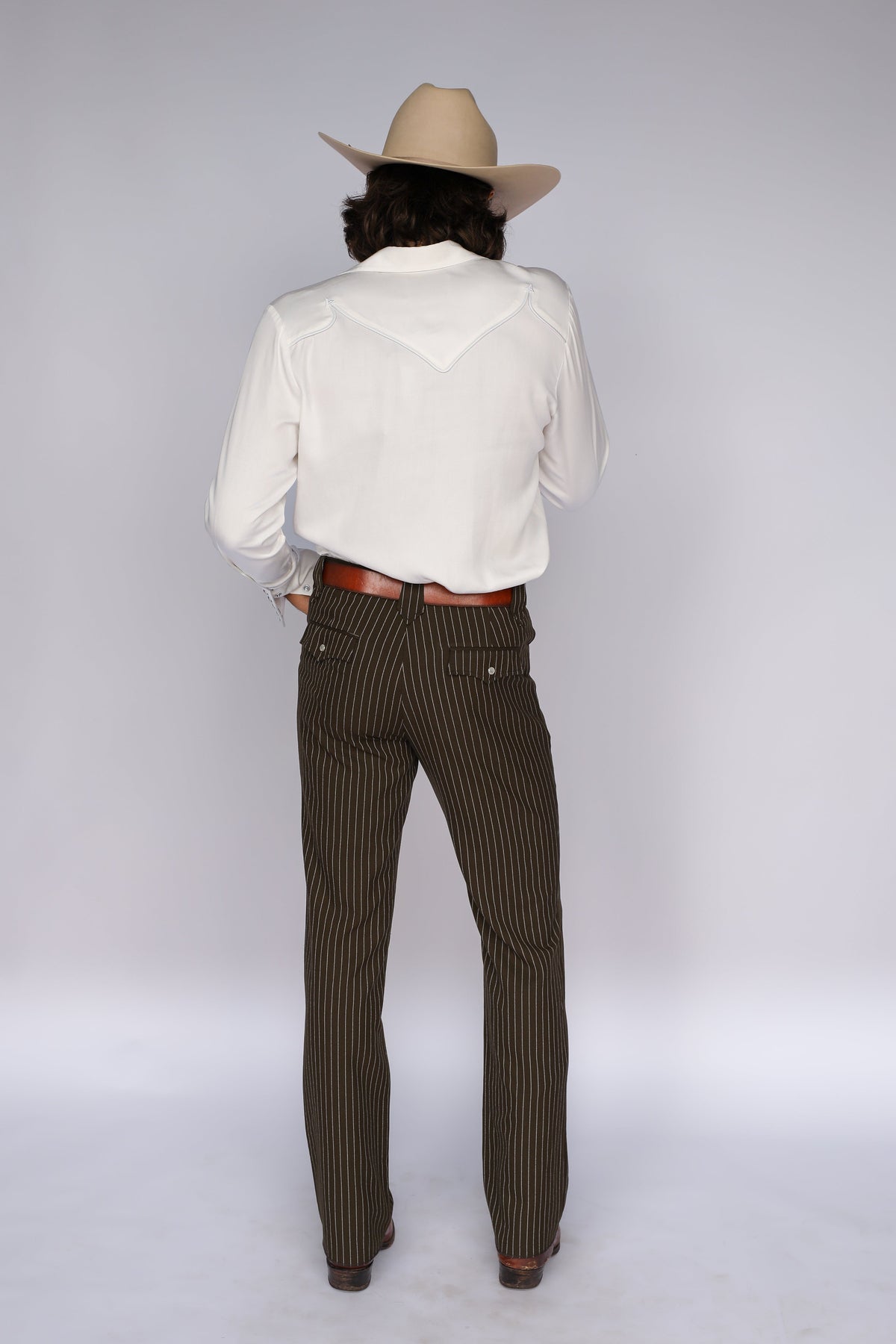 Full back view of the H Bar C Reno men's white shirt tucked into brown pinstripe pants.