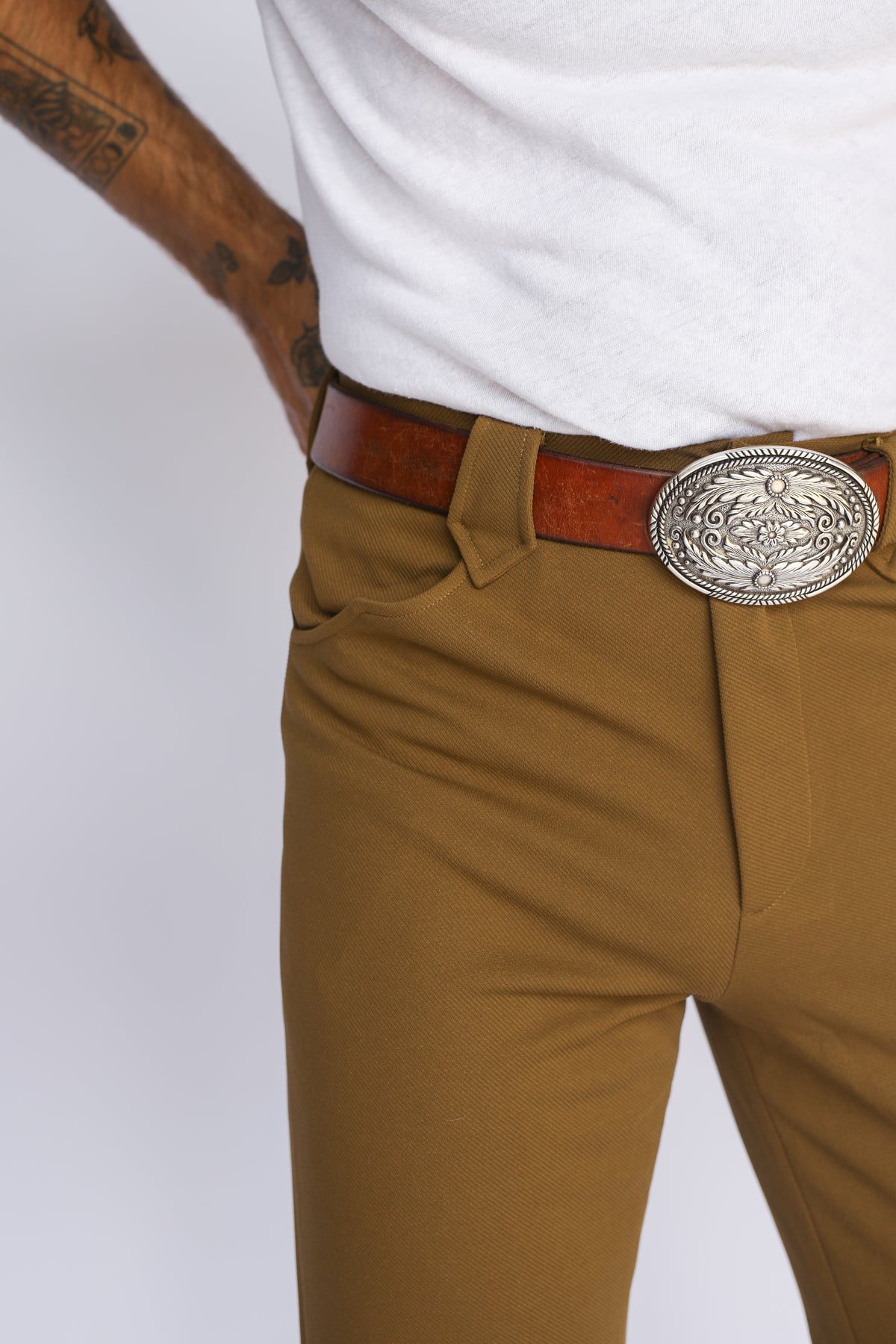Close-up of the front pocket and engraved buckle on the H Bar C Franklin olive pants.