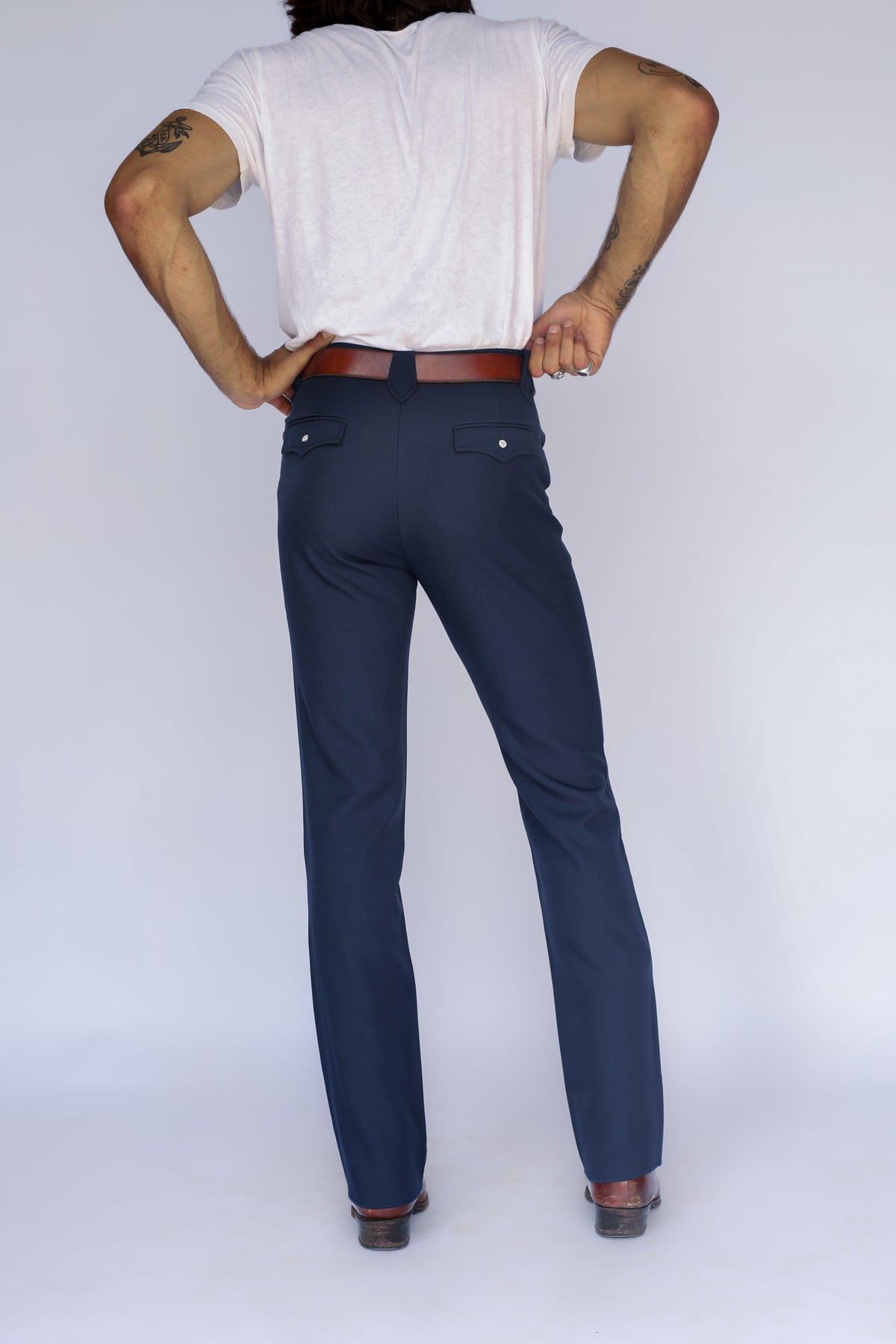 Rear view of the H Bar C Franklin navy stretch western pants with straight leg over boots.