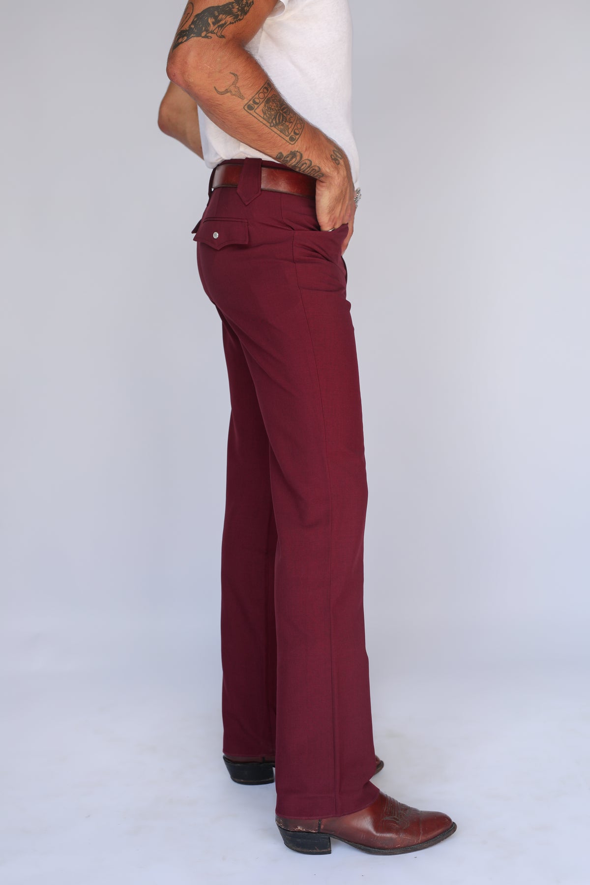 Side profile of the H Bar C Calamity maroon western pants with a straight leg over cowboy boots.