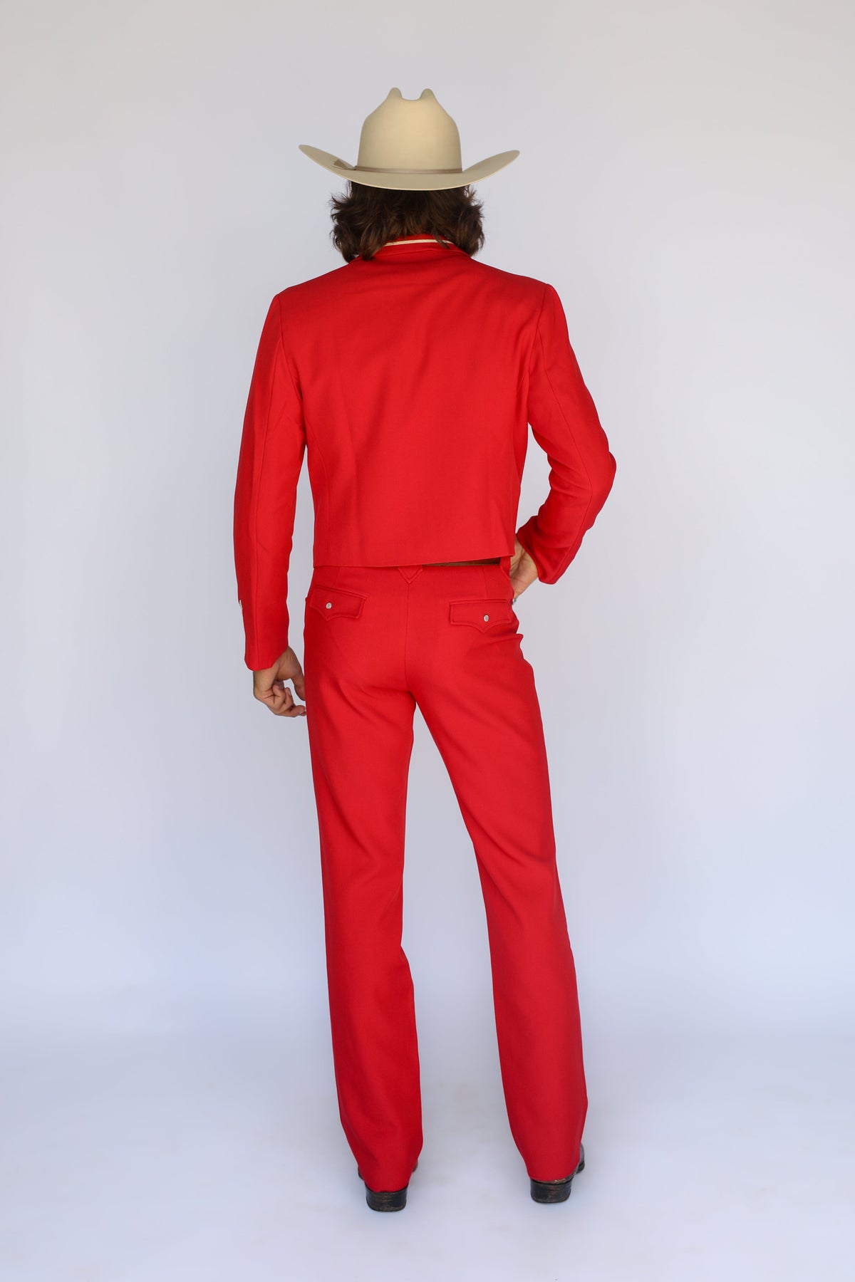 Back view of the H Bar C Franklin red pants worn with the matching red Calamity jacket and a cream cowboy hat.