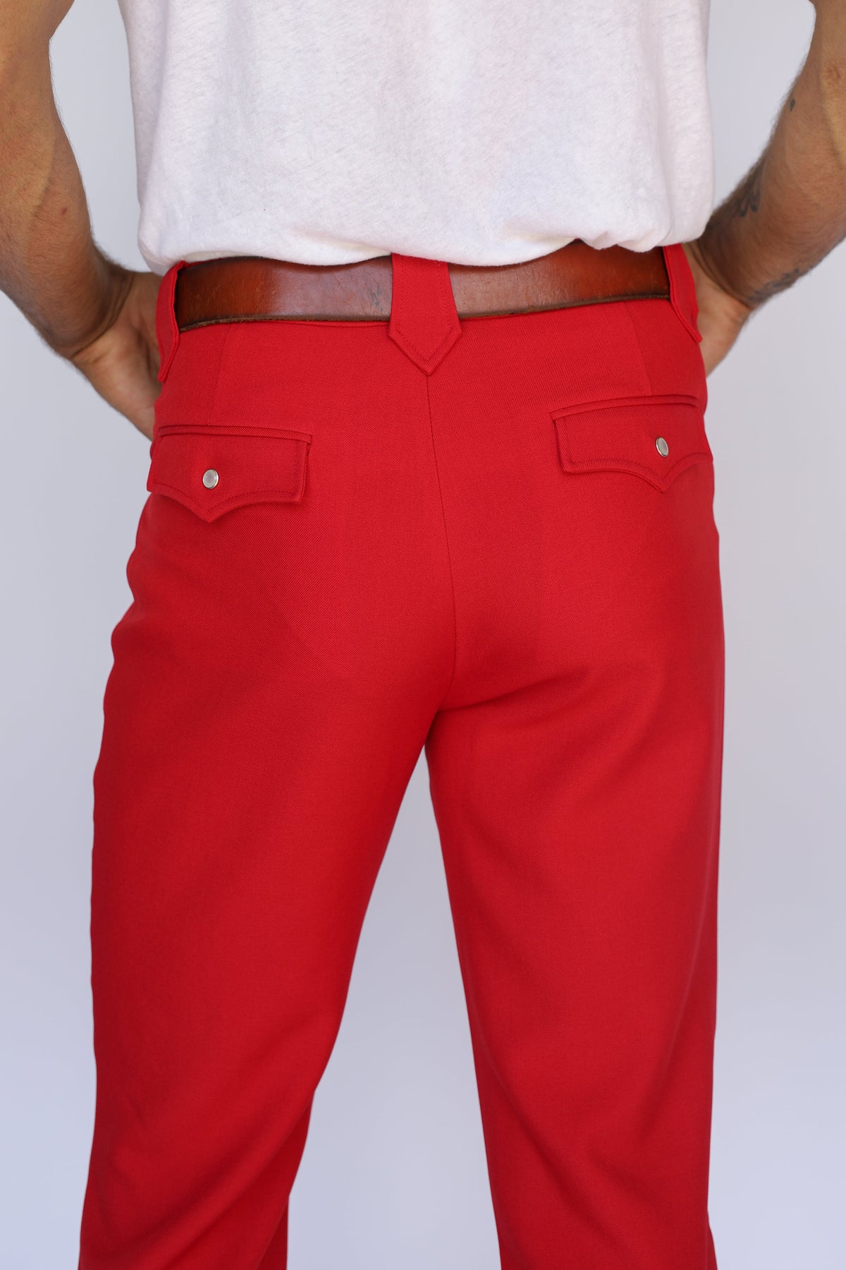Back close-up of the H Bar C Franklin red pants showing the flap back pockets.