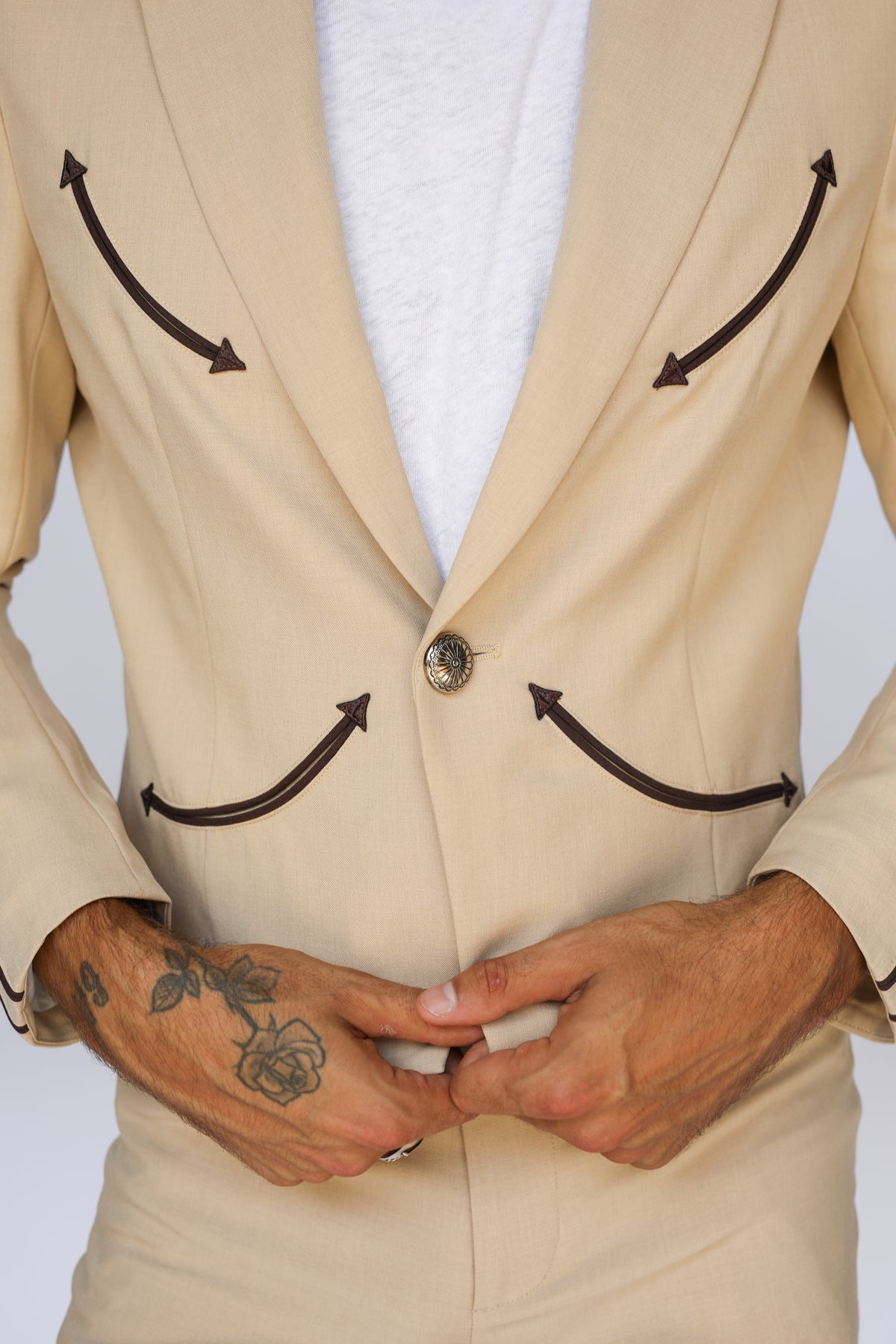 Button front close-up of the H Bar C Calamity tan jacket with brown arrow pockets.