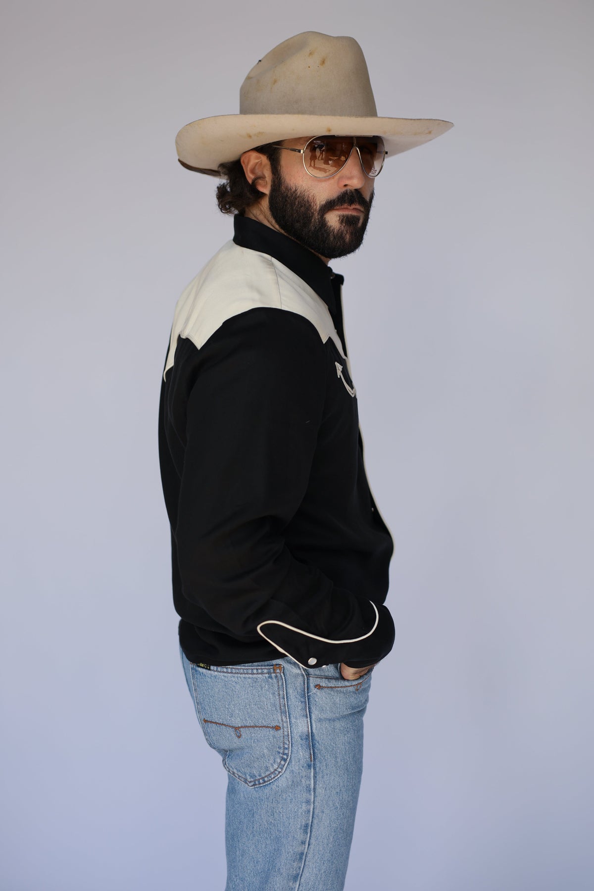 Side profile of the H Bar C San Juan men's black western shirt with cream yoke and piped cuffs.