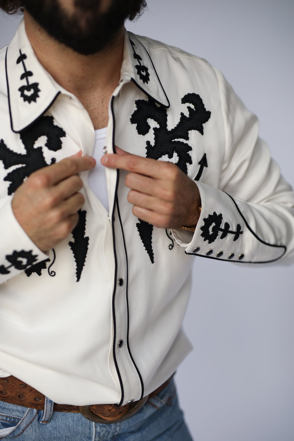 Man snapping the H Bar C Dali white western shirt with black embroidery.