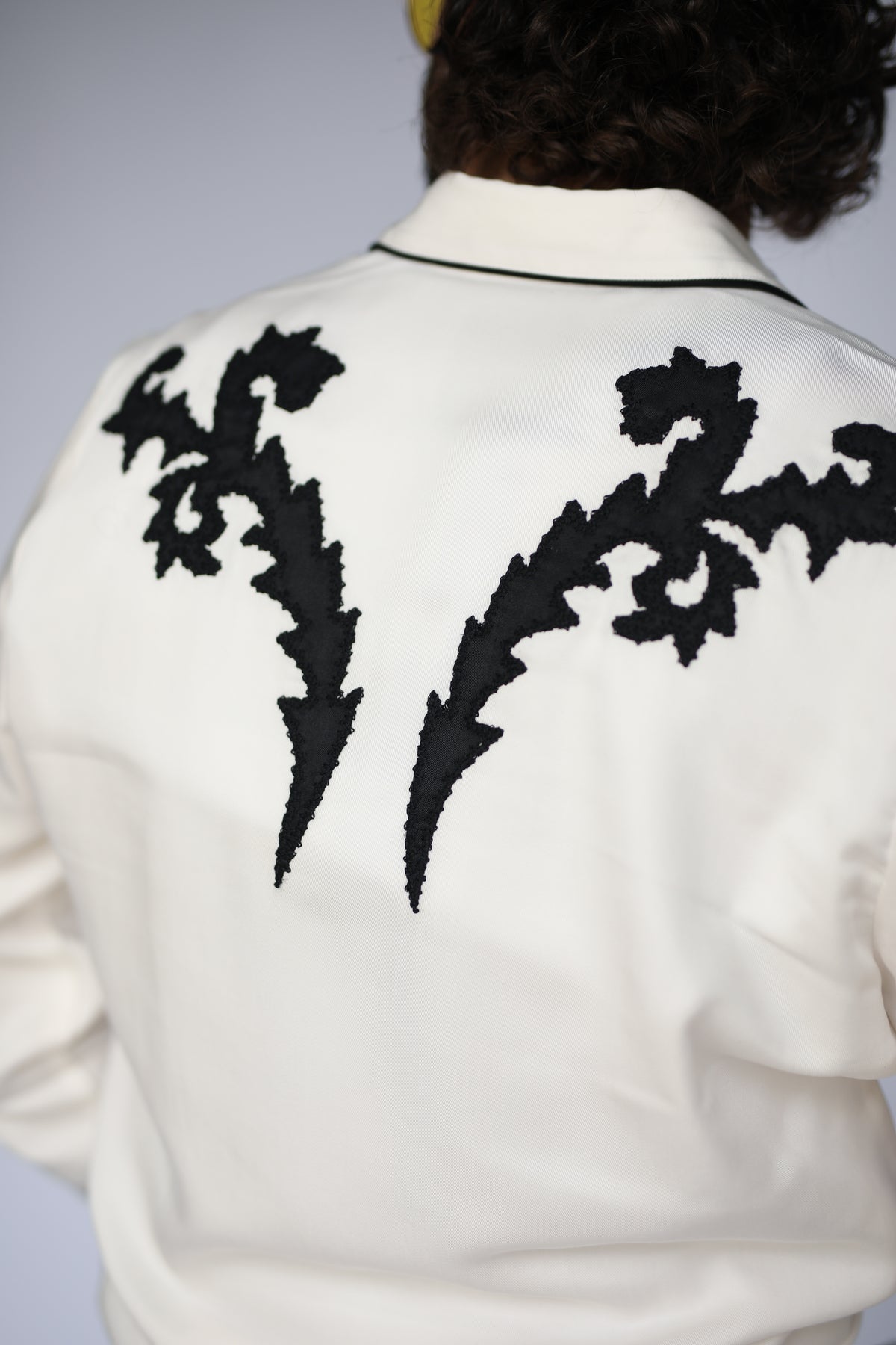 Back yoke close-up of the black flame embroidery on the H Bar C Dali white shirt.
