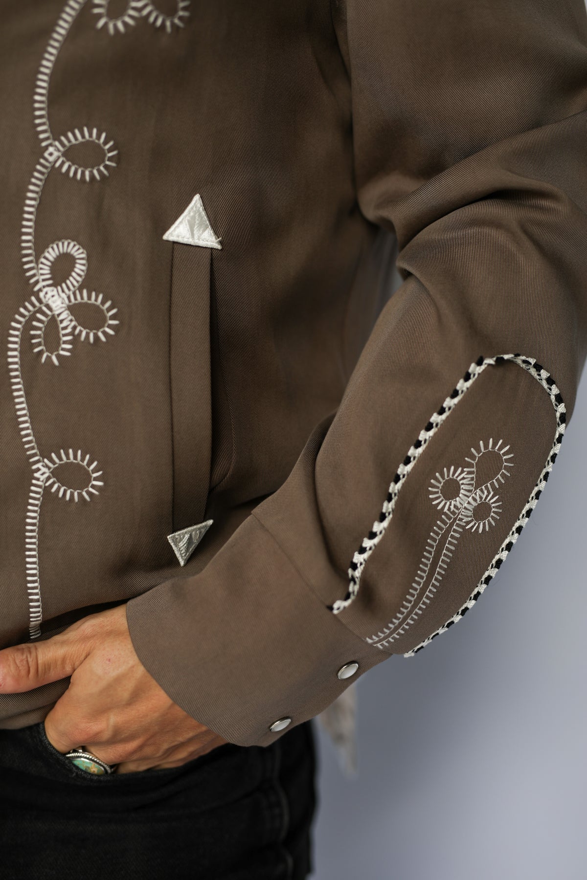 Detail of the embroidered pocket and white arrow tip on the H Bar C Bolero cocoa western jacket.