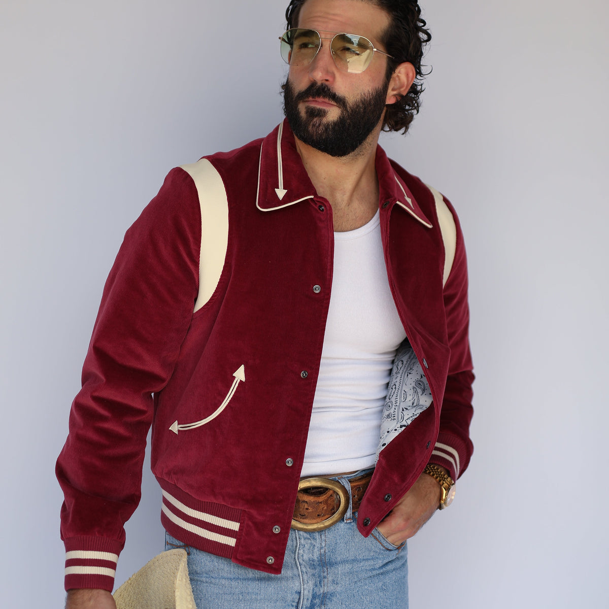 Man holding a cream cowboy hat wearing the H Bar C Silver Lake maroon corduroy jacket over a white tank.