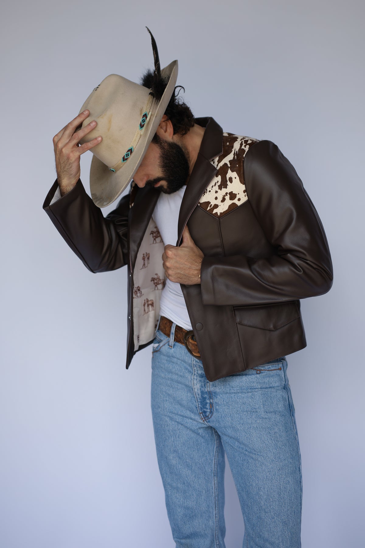 Man tipping his hat showing the patterned lining of the H Bar C Cody leather jacket.