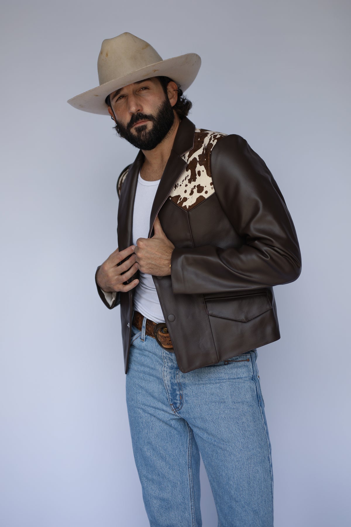 H Bar C Cody brown leather and cowhide western jacket worn open with a cowboy hat.