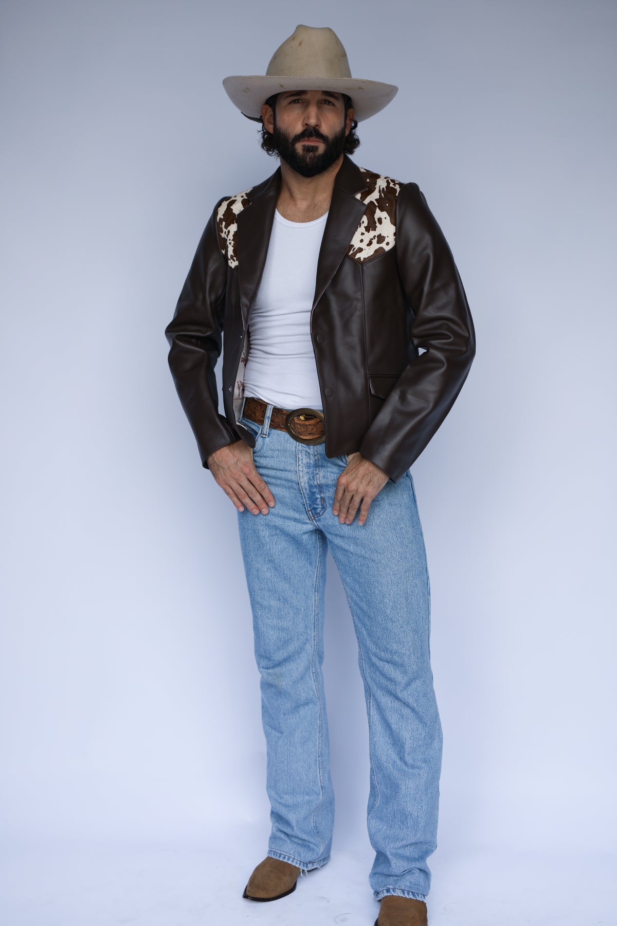 Full length view of the H Bar C Cody brown leather jacket with jeans and cowboy boots.