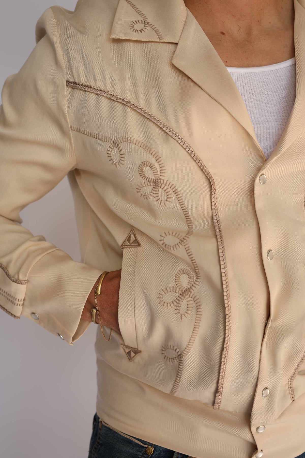 Detail of the embroidered front and pocket on the H Bar C Bolero beige jacket.