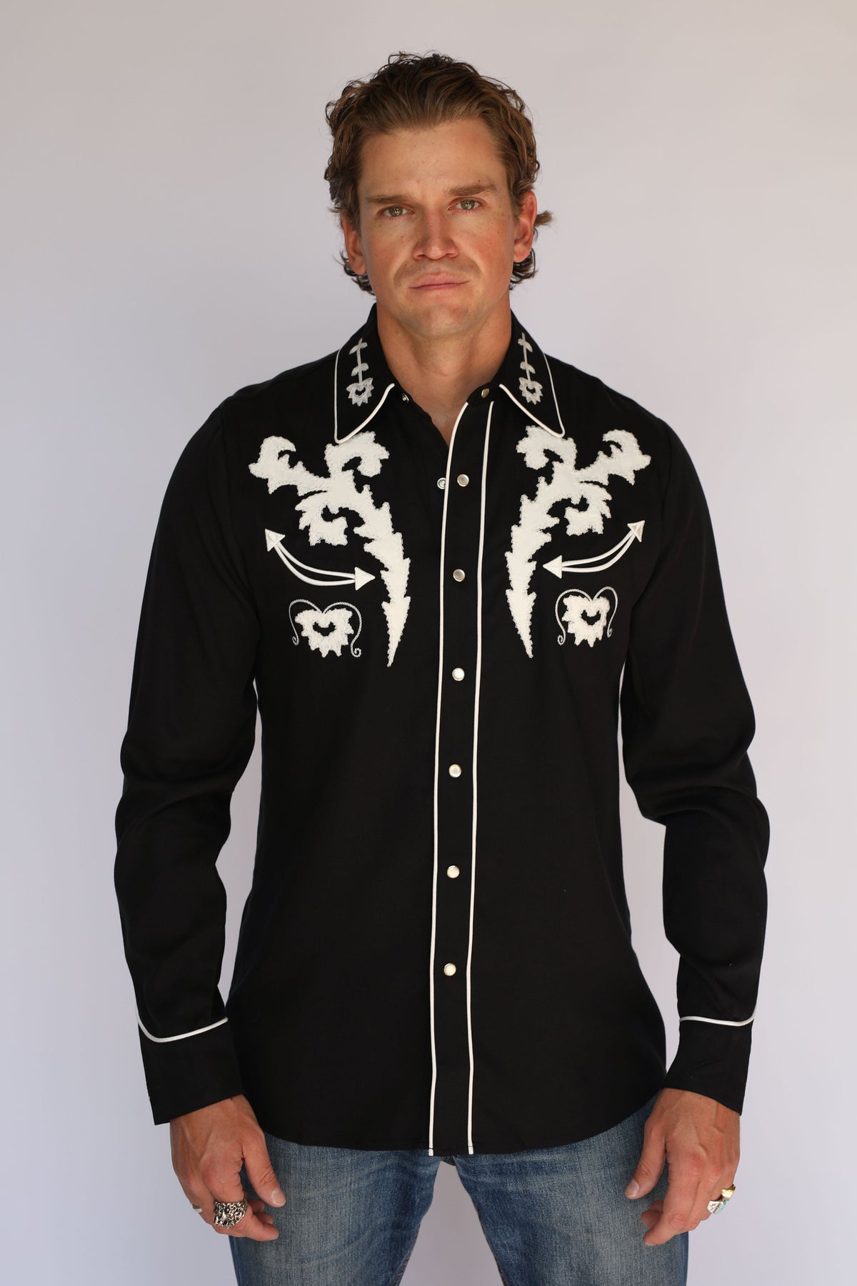 Front view of the H Bar C Dali black western shirt with white embroidered yokes tucked into jeans with a silver buckle.