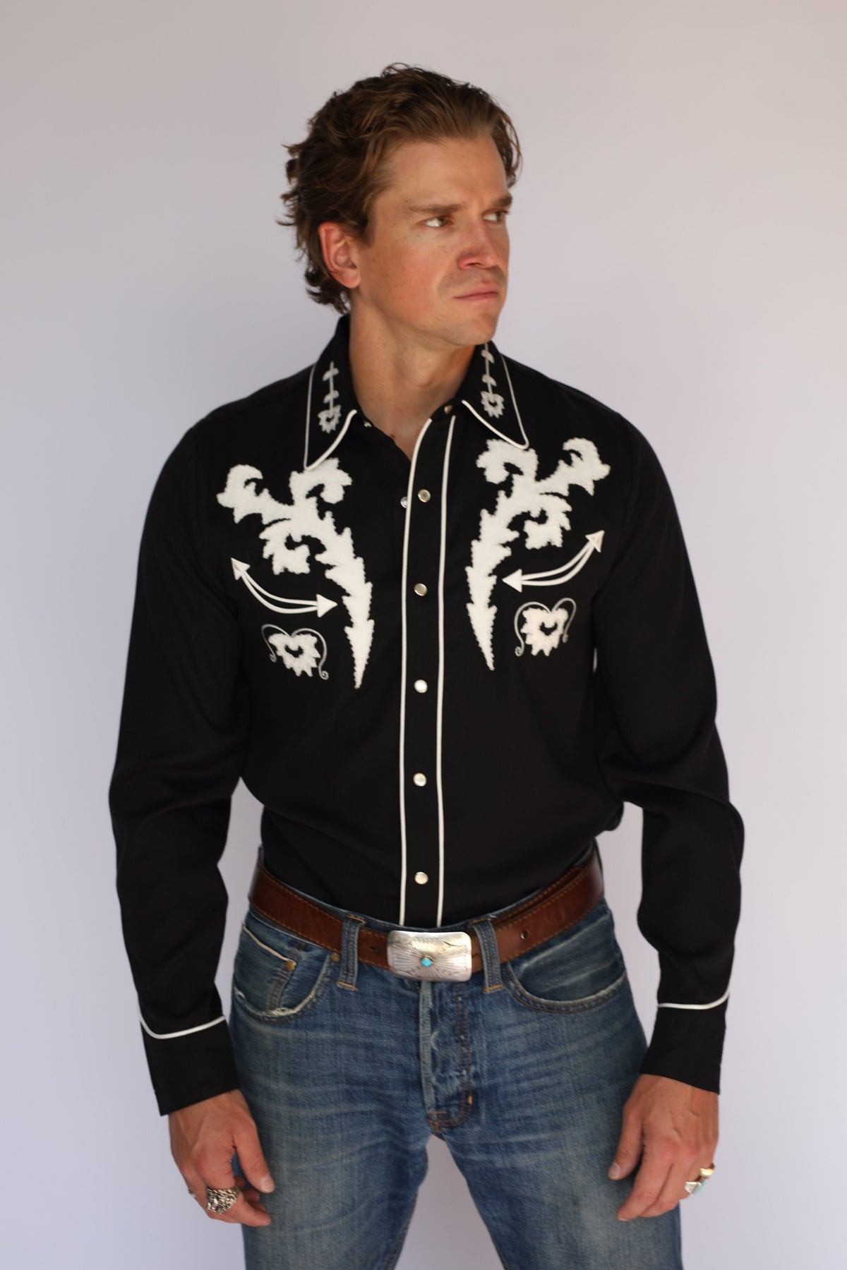 Three-quarter view of the H Bar C Dali black western shirt with white scroll embroidery and white piping.