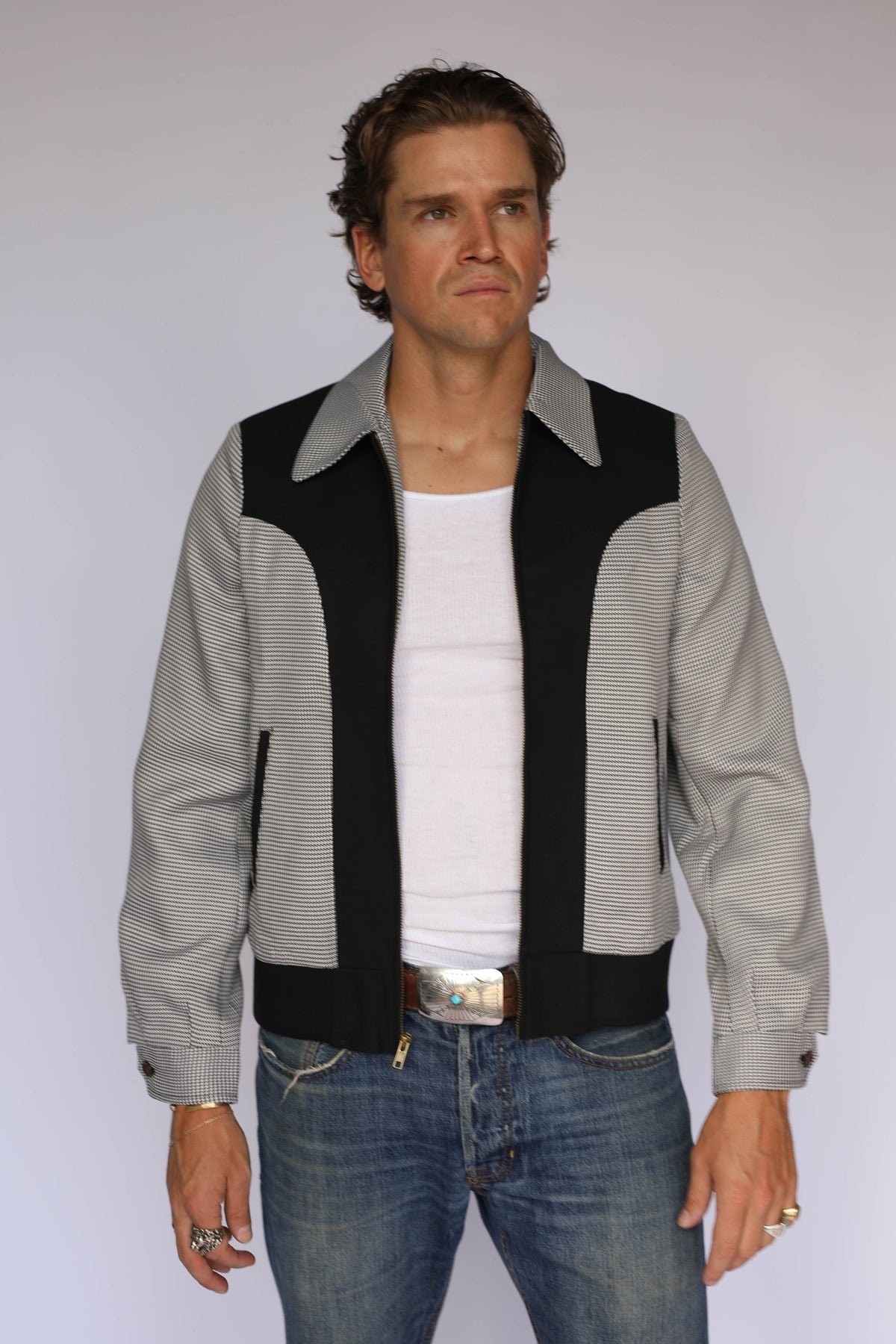 H Bar C Kentucky jacket in black houndstooth with black suede western yoke, zip front, and ribbed waistband, worn by a model