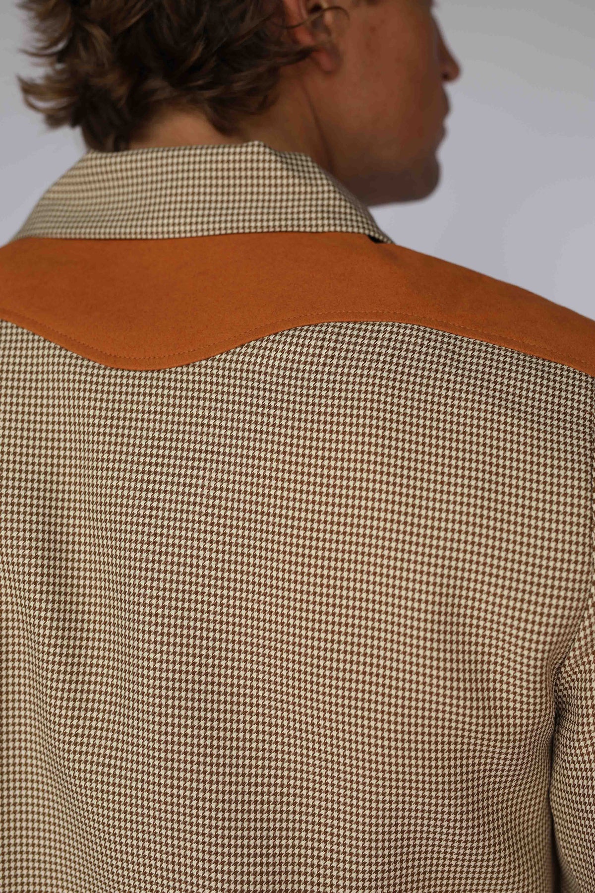 Close-up of the houndstooth fabric and rust suede yoke on the H Bar C Kentucky jacket.