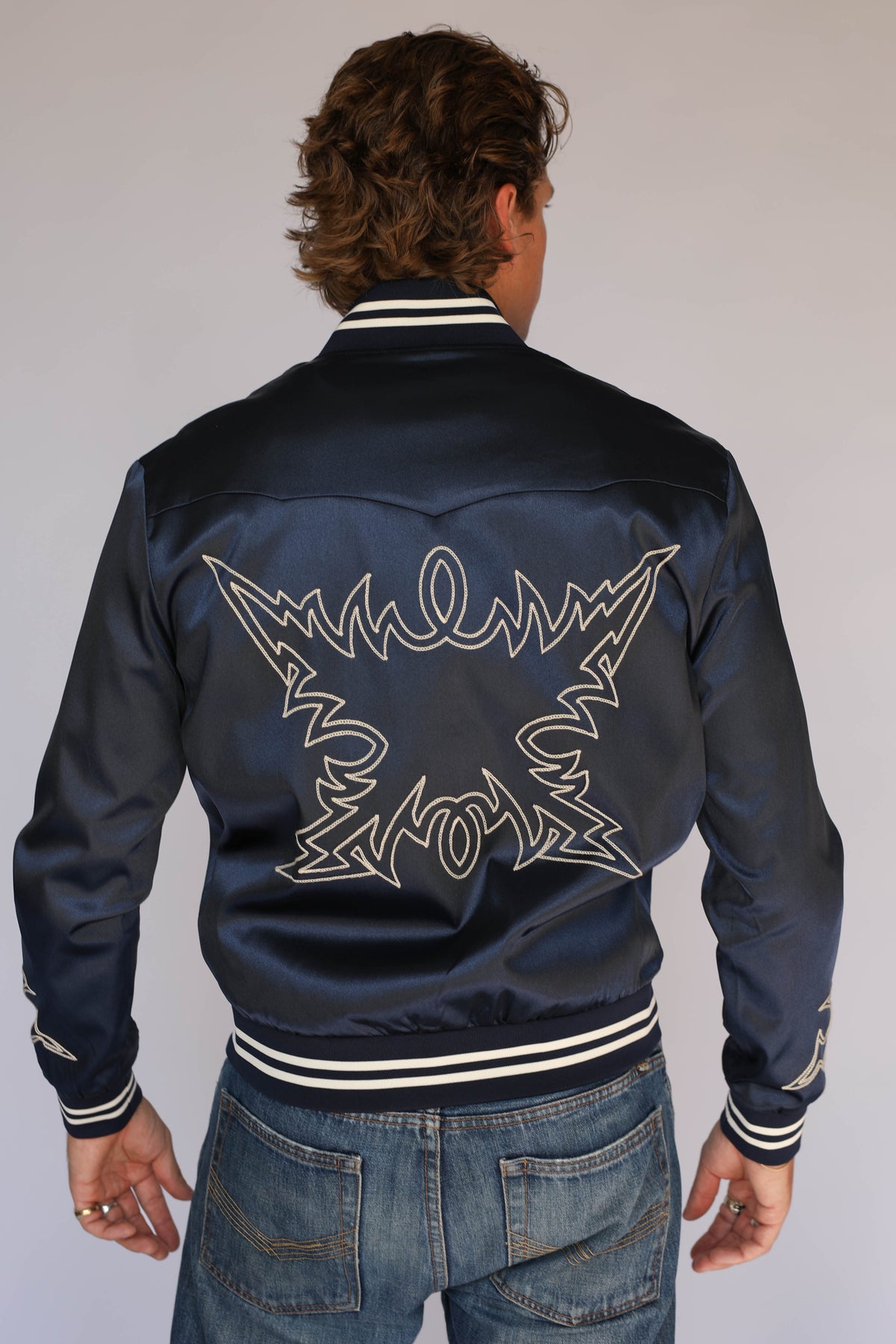 Back view of the H Bar C Odessa navy satin tour jacket, vintage inspired western wear with cream chain stitch embroidery across the back.
