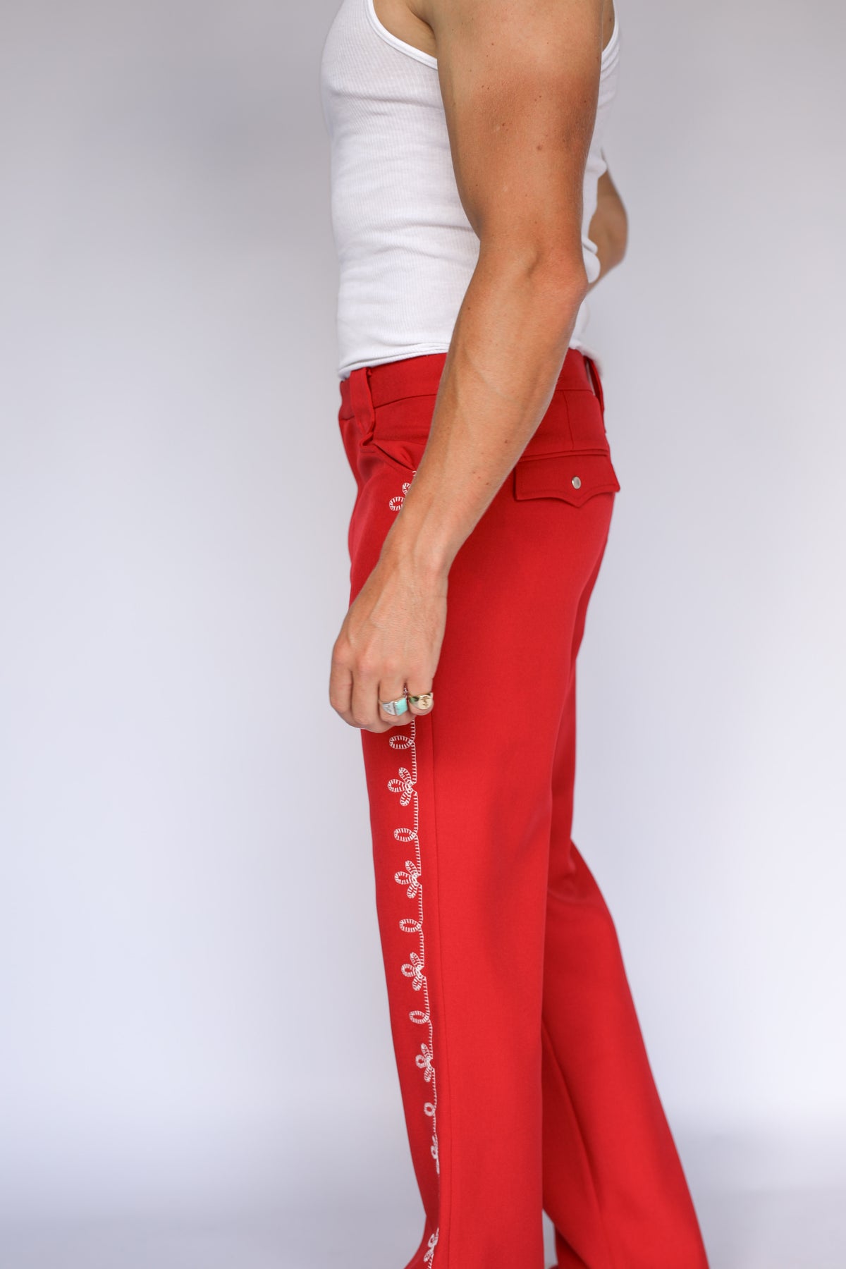 Three-quarter view of the H Bar C red Bolero pants with white floral side embroidery.