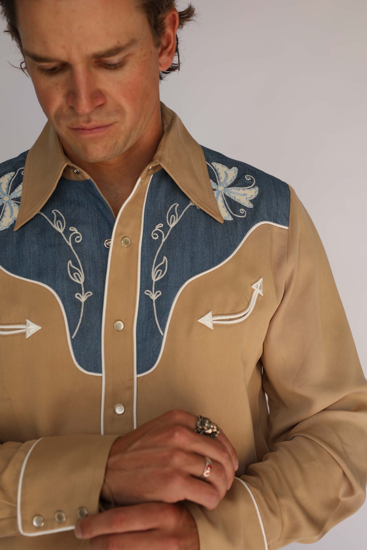 Close-up of the H Bar C Telluride shirt chest, vintage inspired western wear with white arrow embroidery, piping, and pearl snaps.