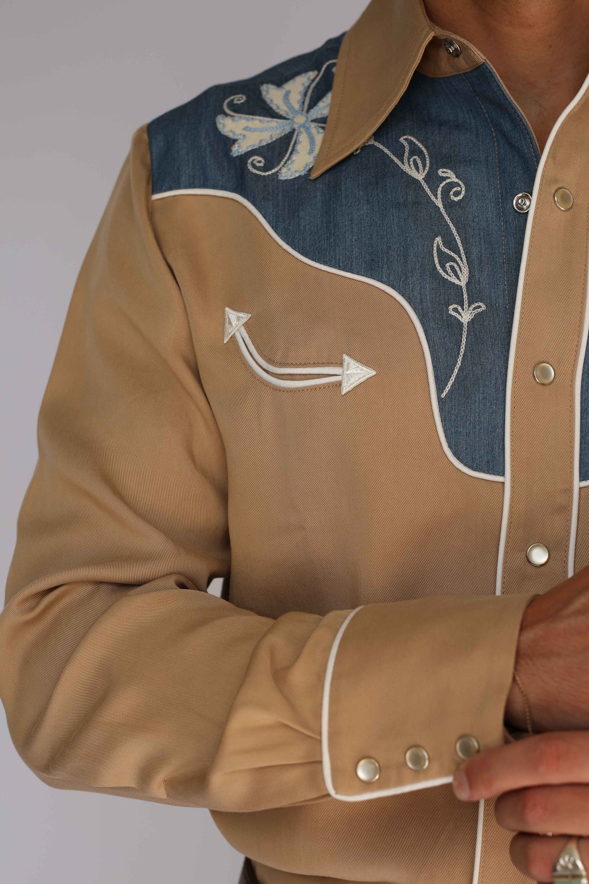 Detail of the white and blue floral embroidery and chain stitch vines on the denim yoke of the H Bar C Telluride vintage western wear shirt.