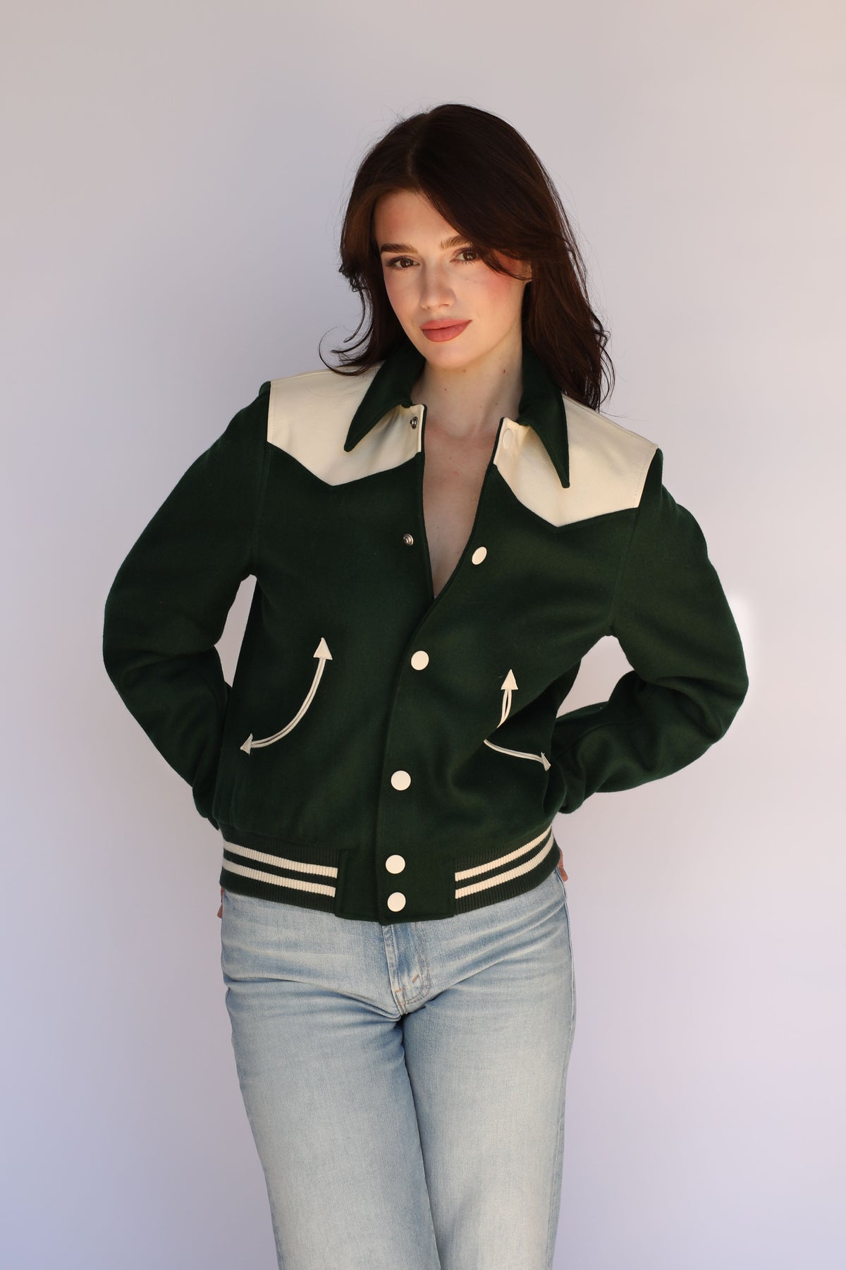 Woman wearing The Vail unisex jacket by H Bar C in green with cream yoke and light jeans.
