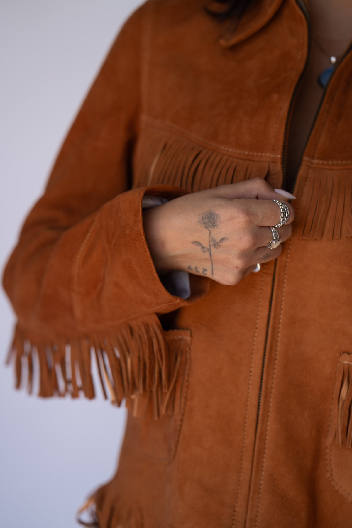 Close-up of the zipper and suede fringe on the H Bar C Omaha women's western jacket.