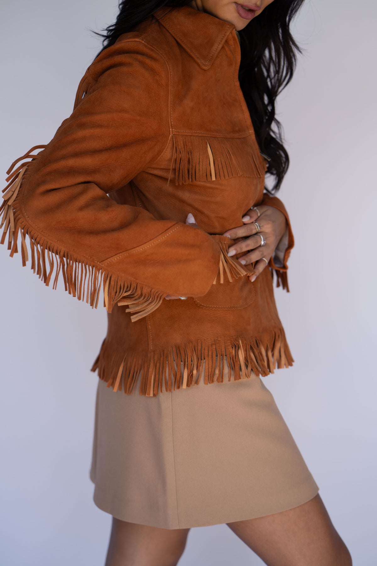 H Bar C Omaha cropped tan suede fringe jacket with a high collar and beige mini skirt.