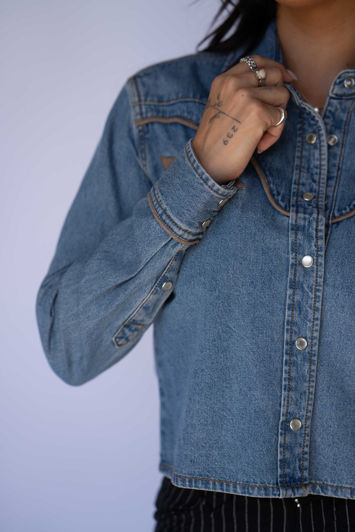 Snap cuff and pocket detail of the Rustler x H Bar C women's cropped denim western shirt.