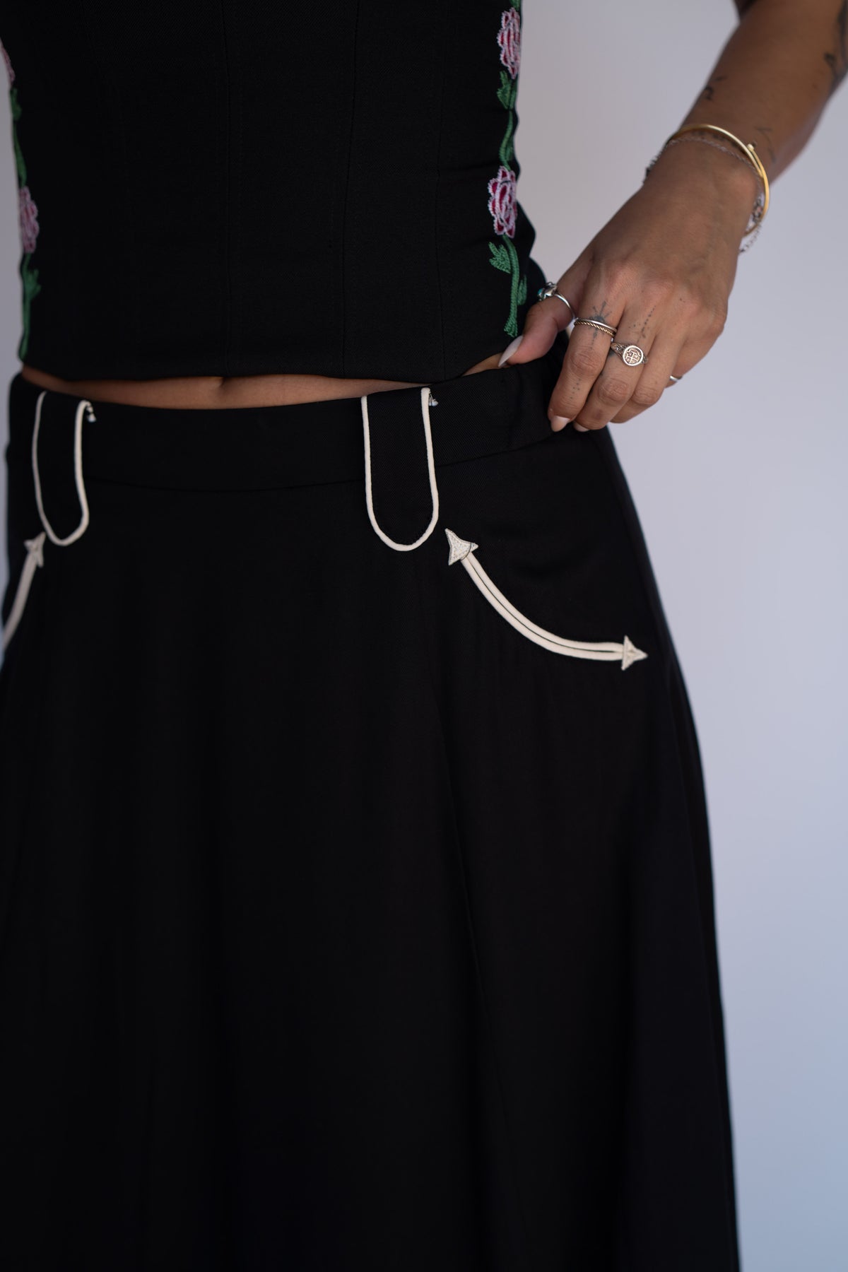 Waist detail of the H Bar C Santa Fe black skirt with white piped western pocket and banded waist.