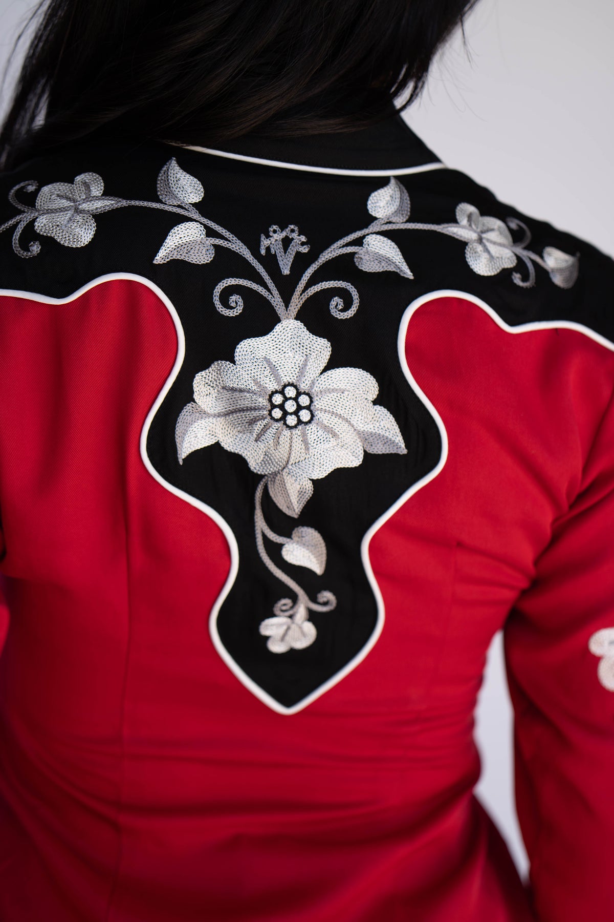 Back yoke detail of the H Bar C Santa Ana red shirt with a large white embroidered flower on black.