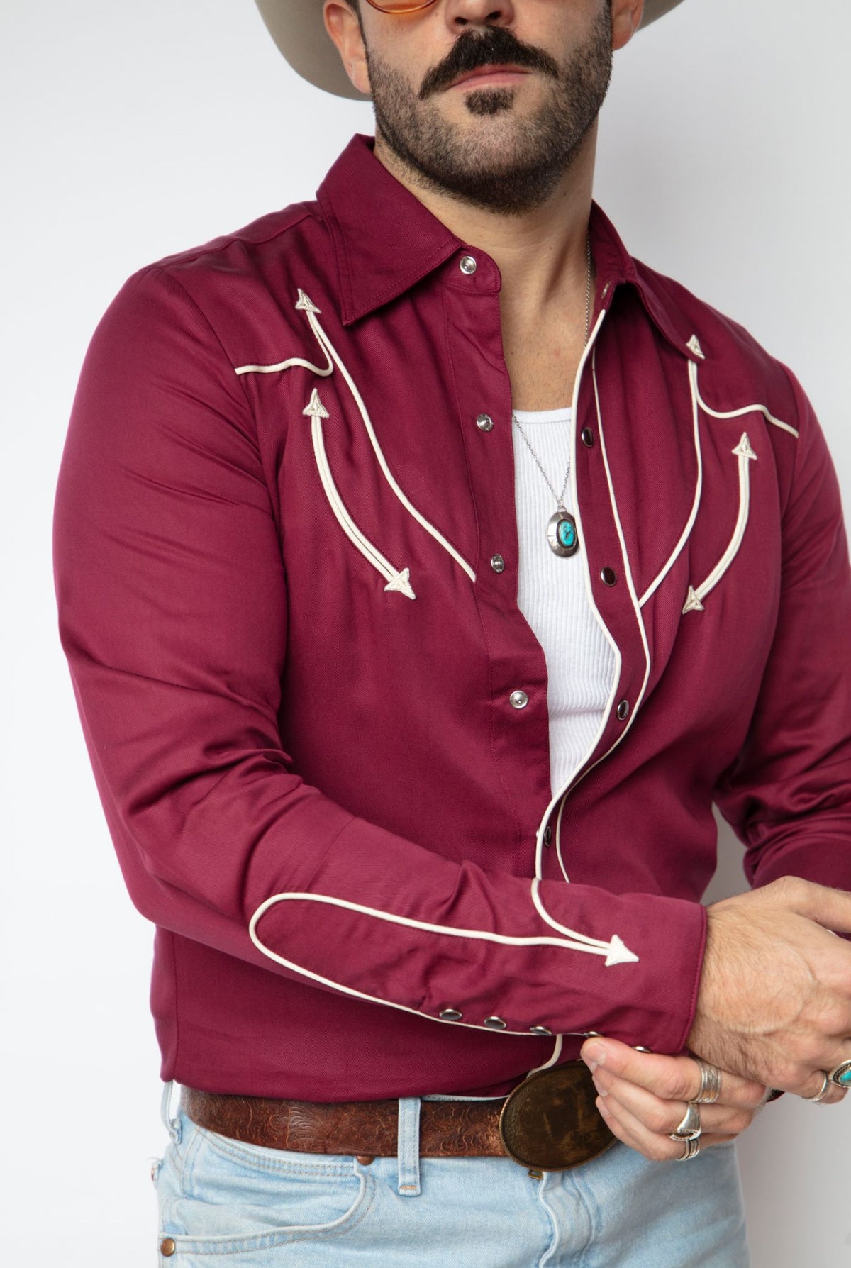 Close-up of the off white piped arrows and snaps on the H Bar C Reno maroon shirt.