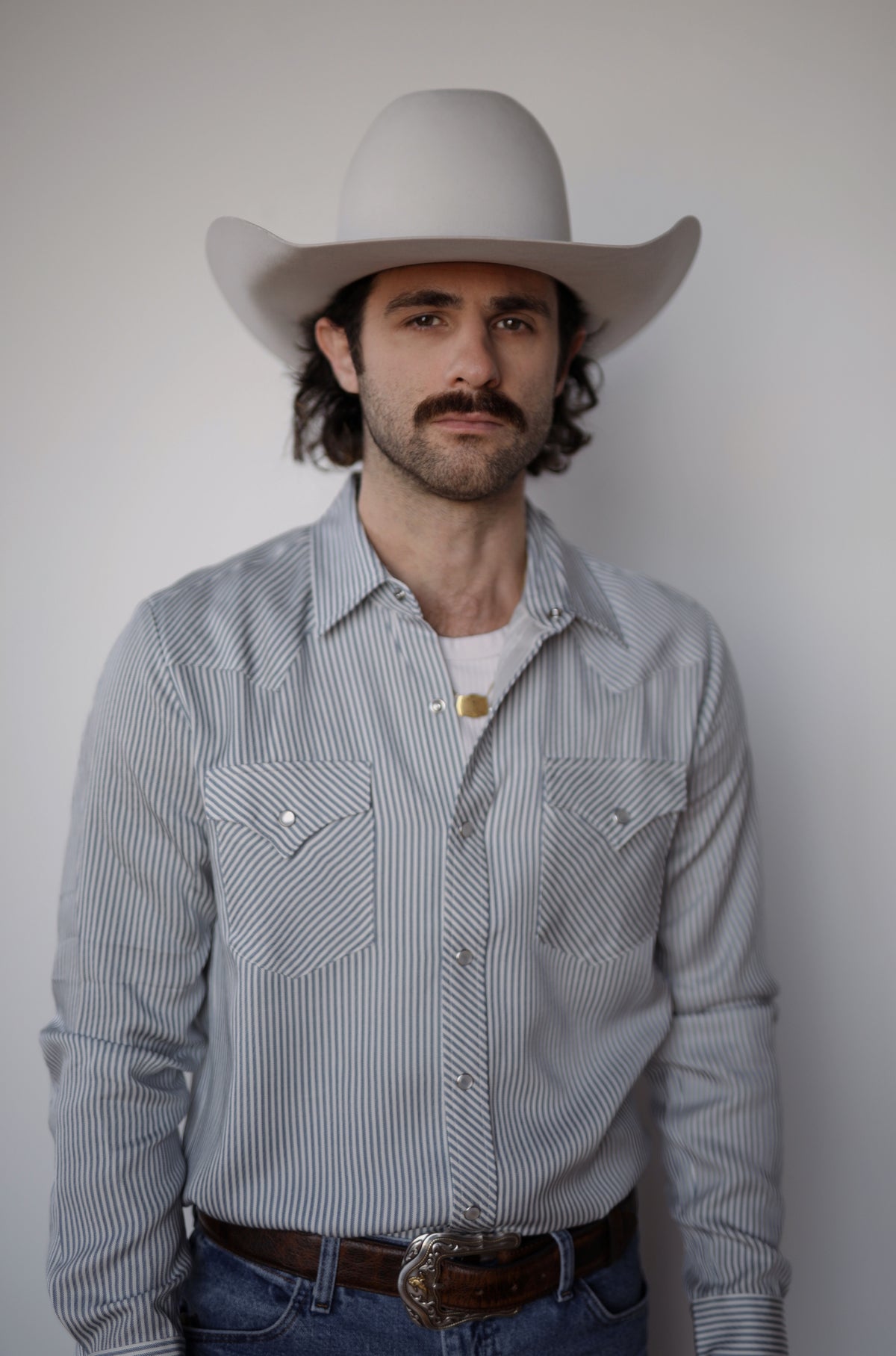 Front view of the H Bar C Folsom striped western shirt tucked into jeans with a brown belt.