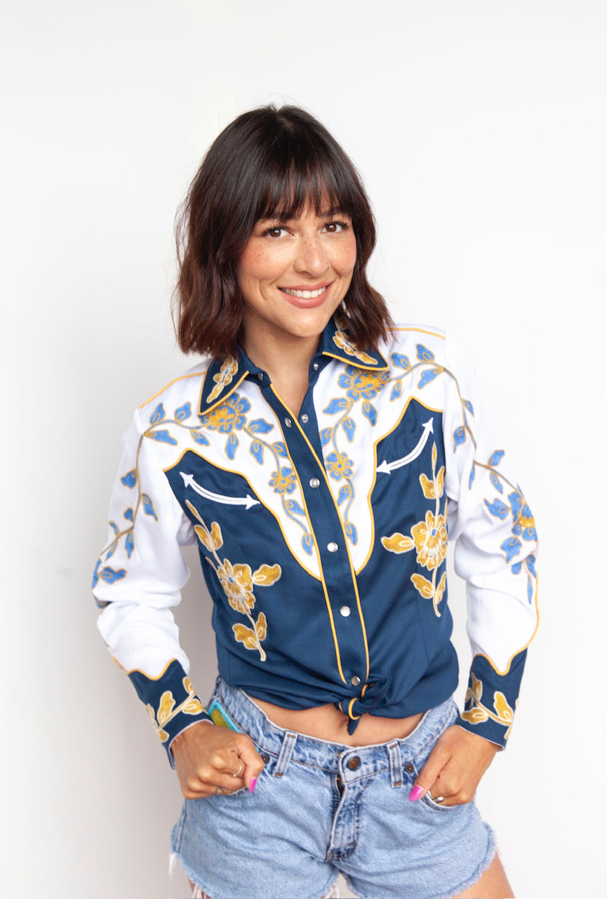 Front view of the H Bar C Charleston women's navy shirt with gold floral embroidery on white sleeves.