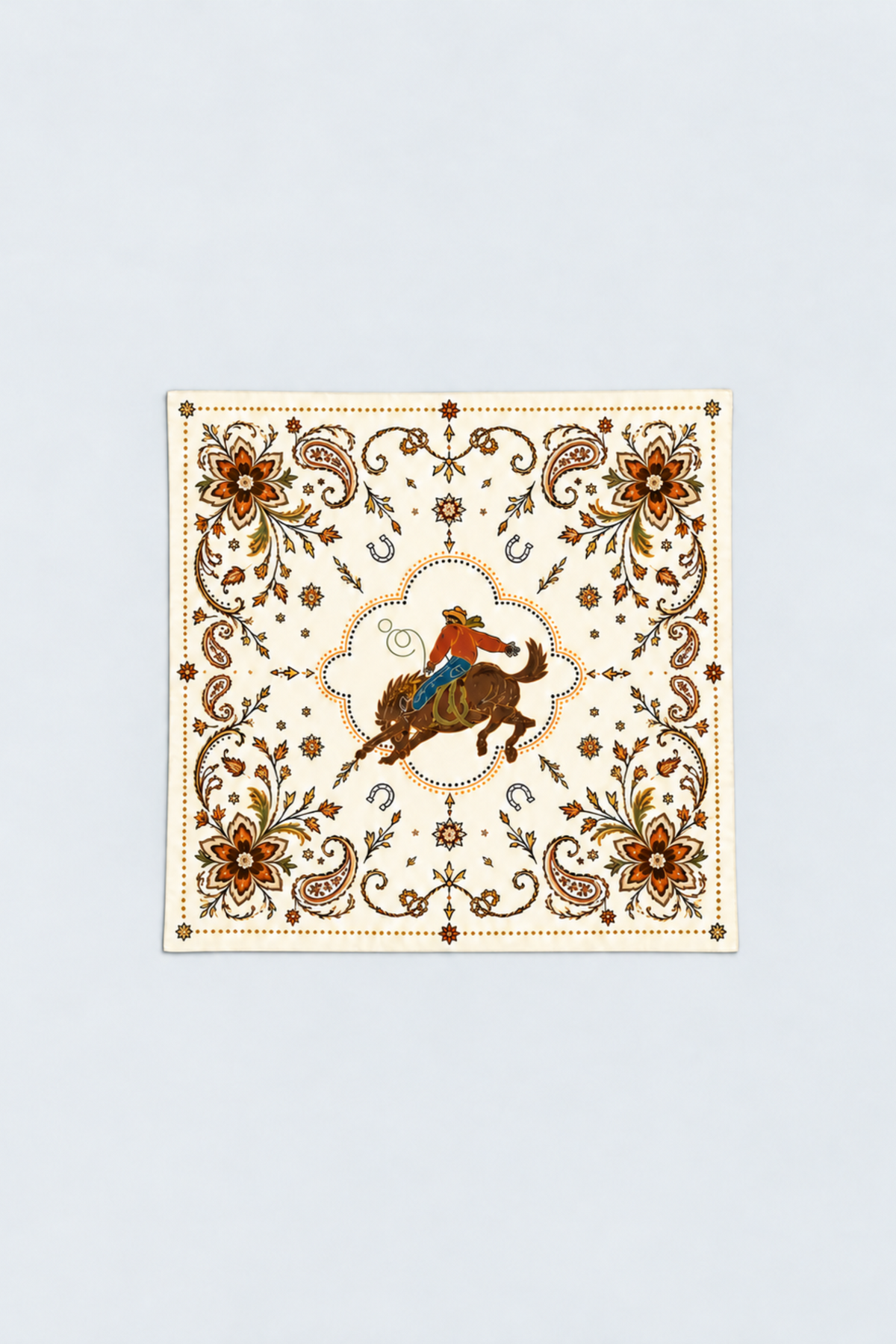 H Bar C Ivory Calabasas silk scarf laid flat, an ivory western bandana with a bronc rider center, orange paisley, florals, and horseshoes, 75 cm square.
