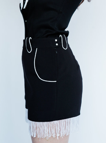 Side view of the H Bar C Marfa black shorts with white piped pocket and fringe.