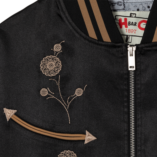 Close-up of the Gibson J-200 floral embroidery and tan arrow pocket on the HBarC x Gibson J-200 Odessa black satin jacket.