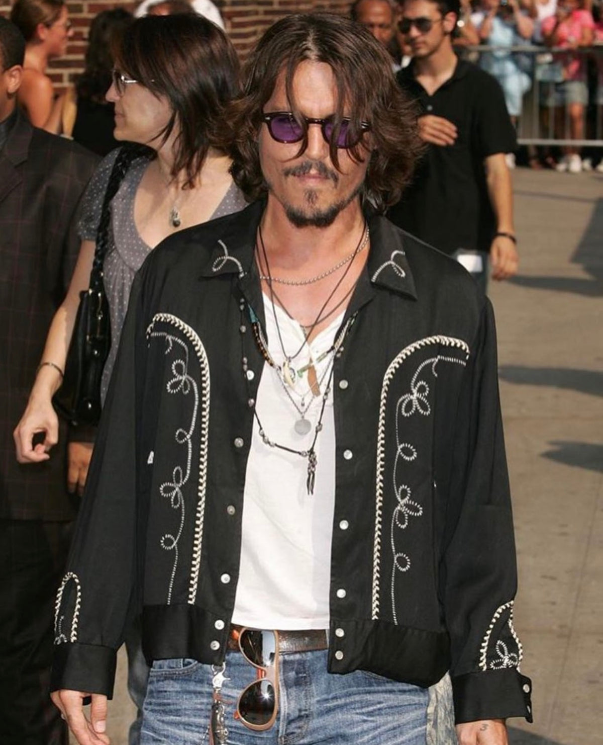 Johnny Depp wearing the H Bar C Bolero black and white embroidered western jacket over a white tee and jeans.